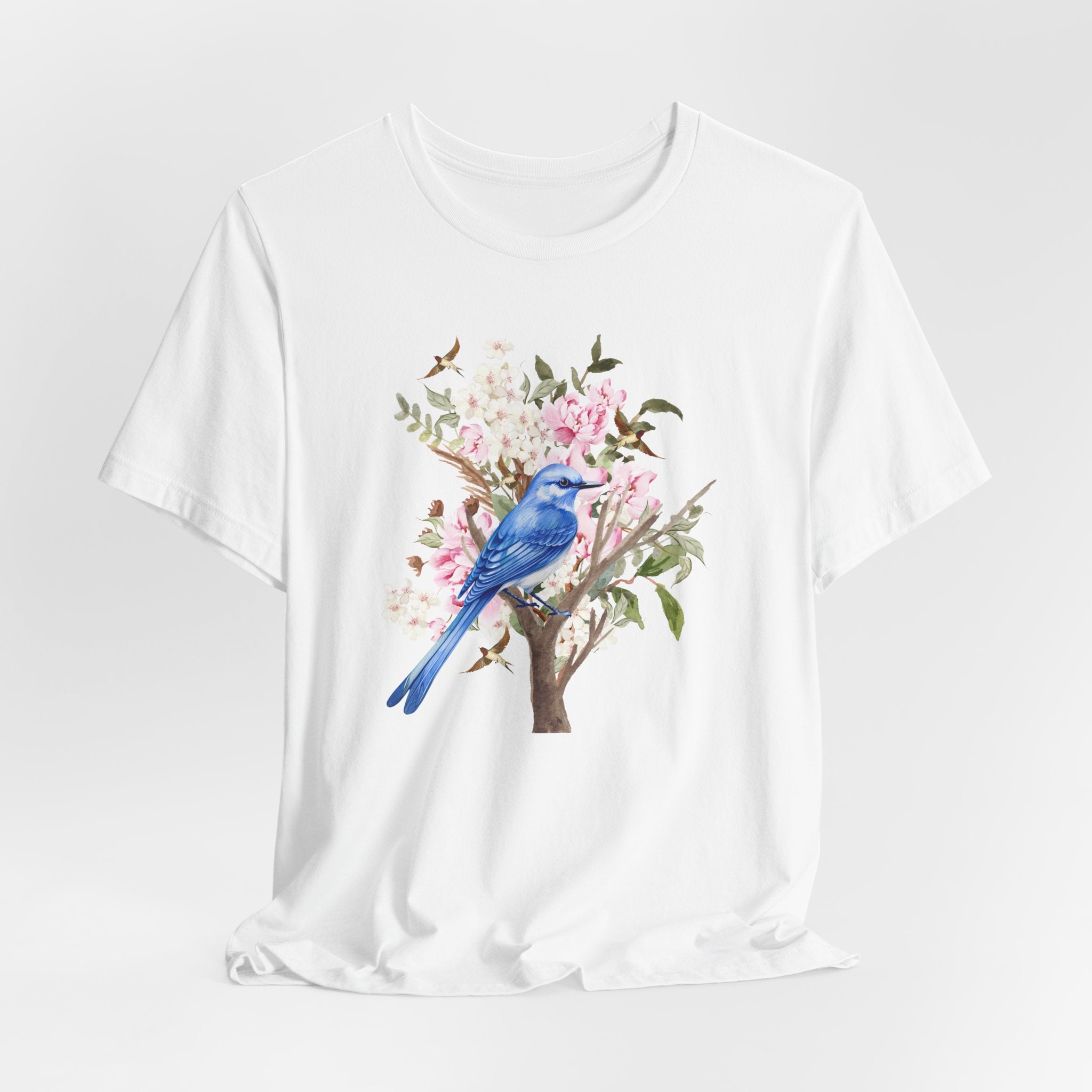White t-shirt with a blue bird and floral design on a white background