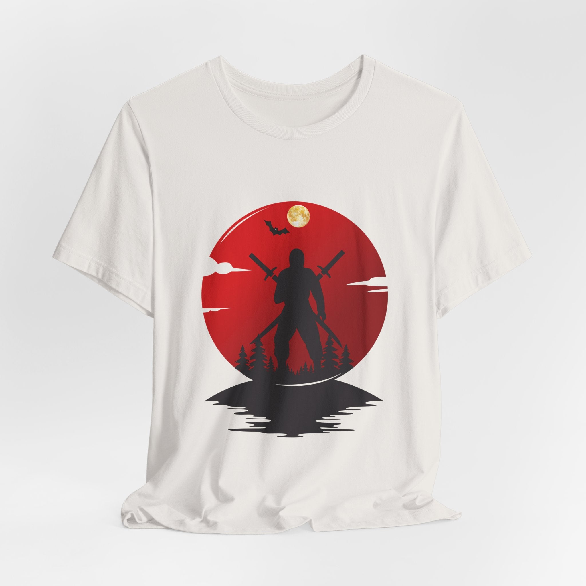 White t-shirt with a red circular design featuring a silhouette of a person holding two swords against a moonlit sky.