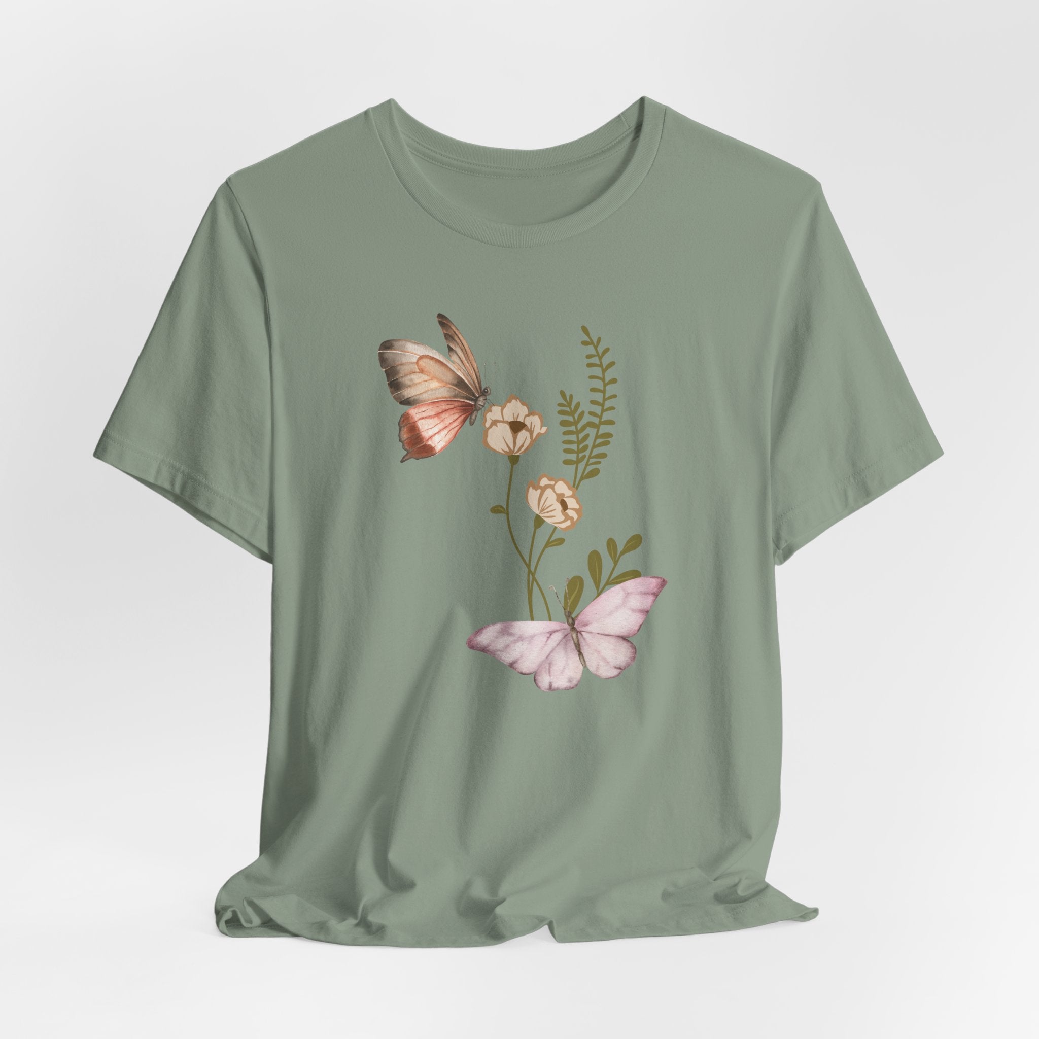 Green t-shirt with butterfly and floral design on a light gray background