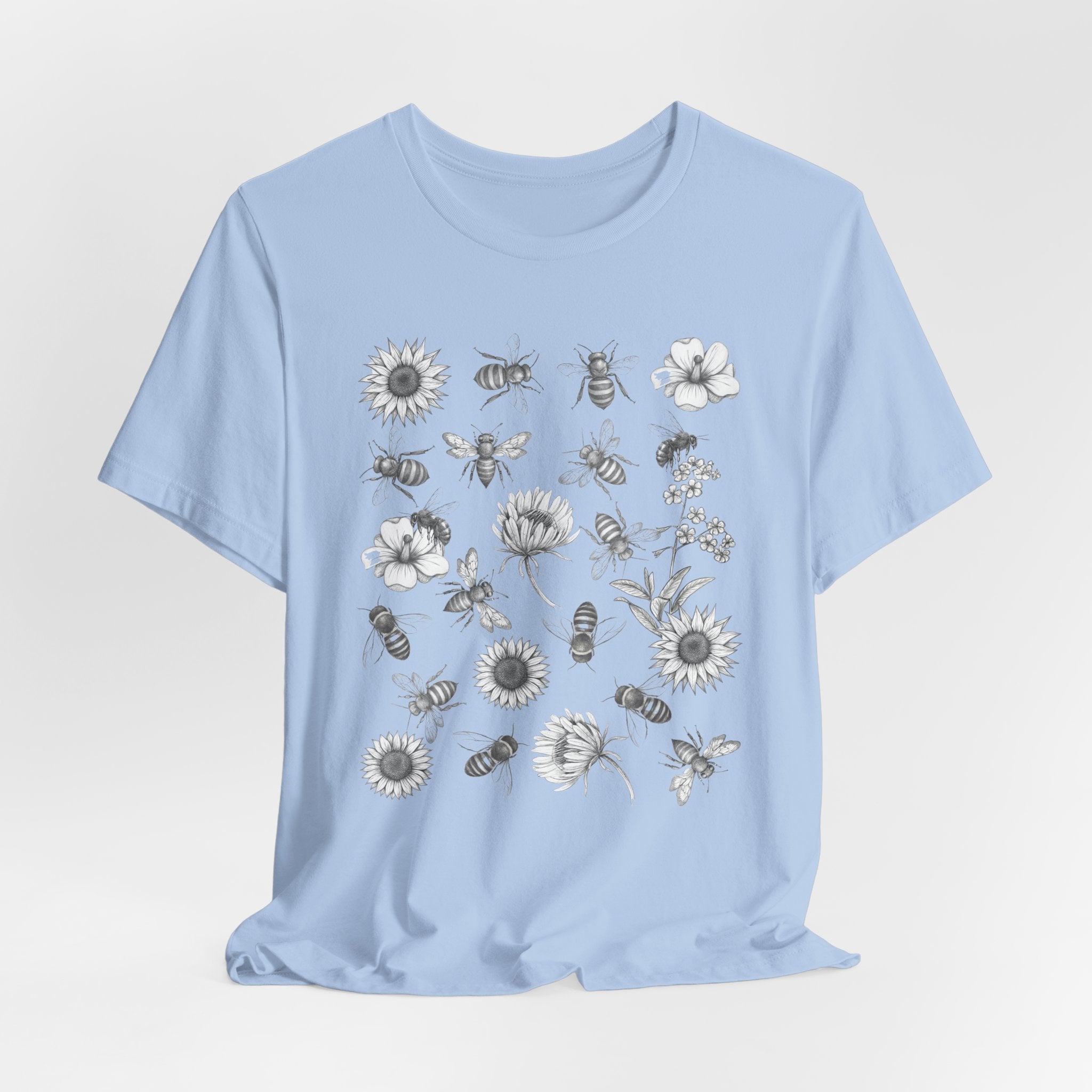 Light blue t-shirt with bee and flower pattern on a light gray background
