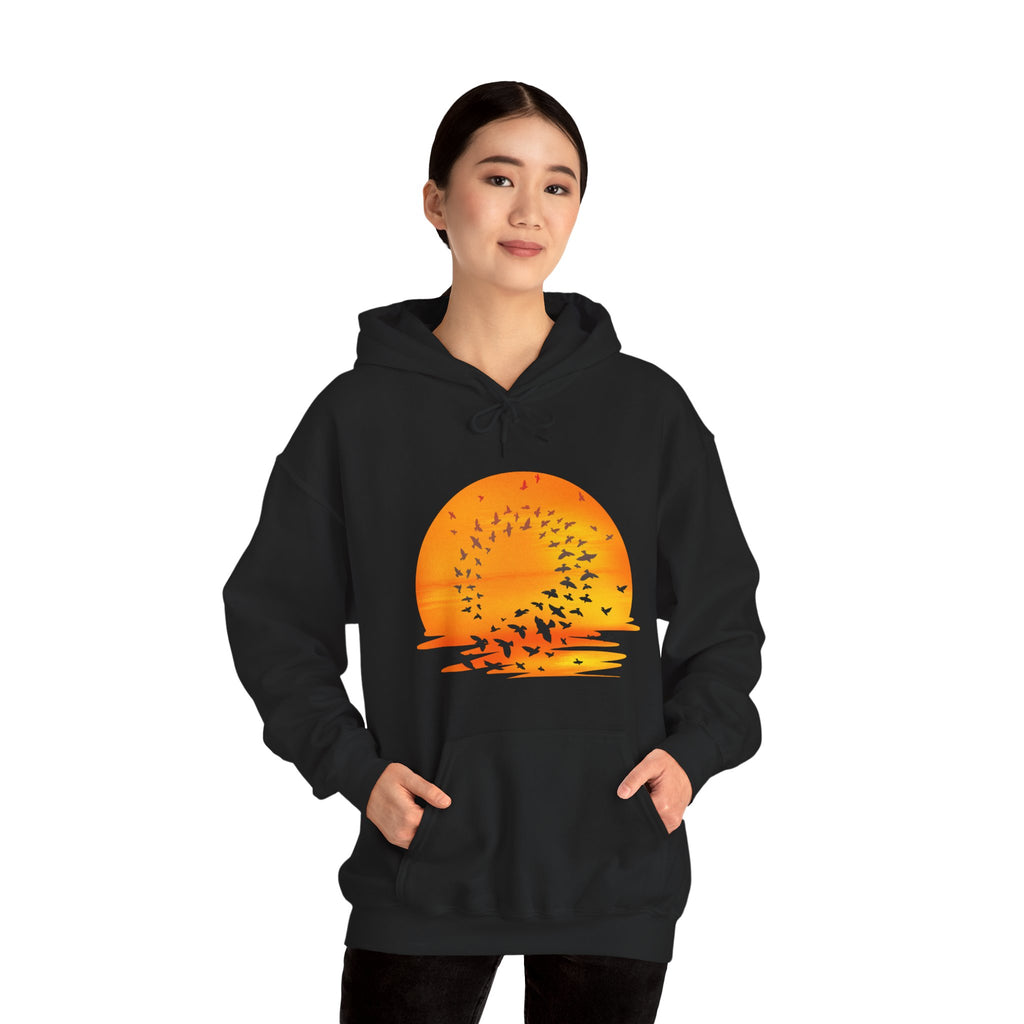 Person wearing a black hoodie with a sunset graphic design on a white background