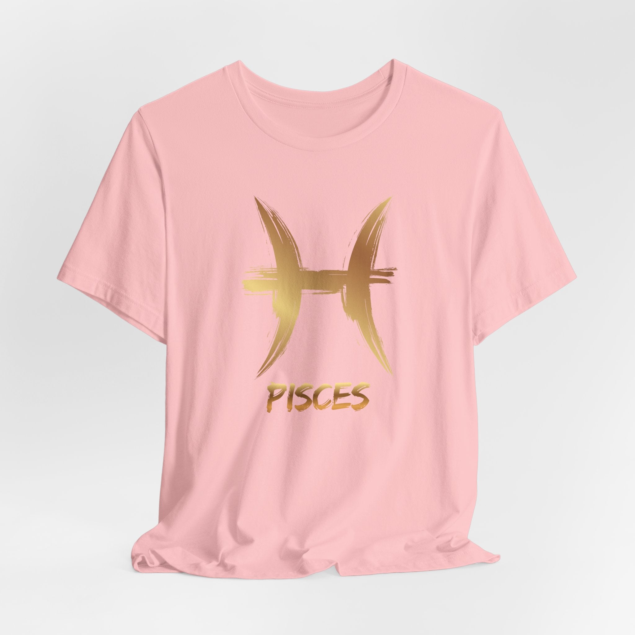Pink t-shirt with gold Pisces symbol and text on a light gray background