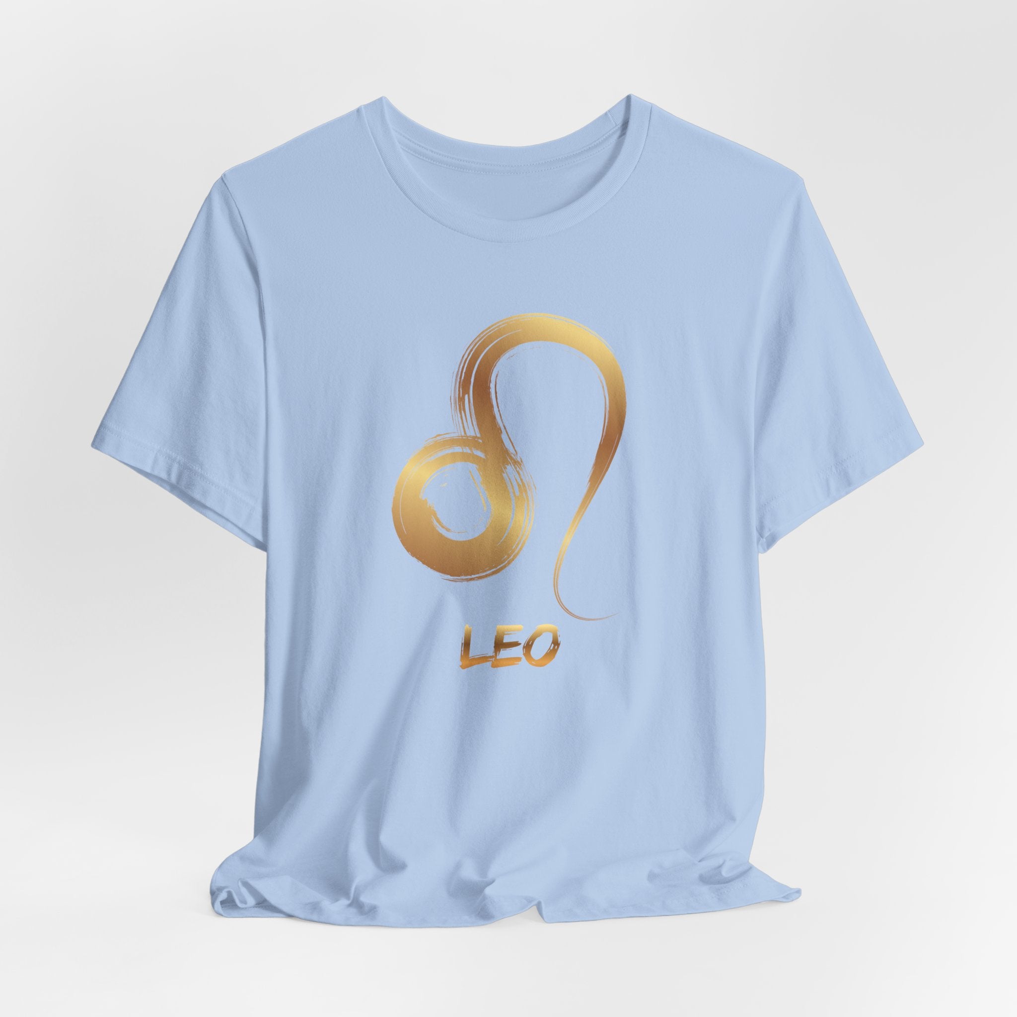Light blue t-shirt with a gold lion design and 'LEO' text on a light gray background