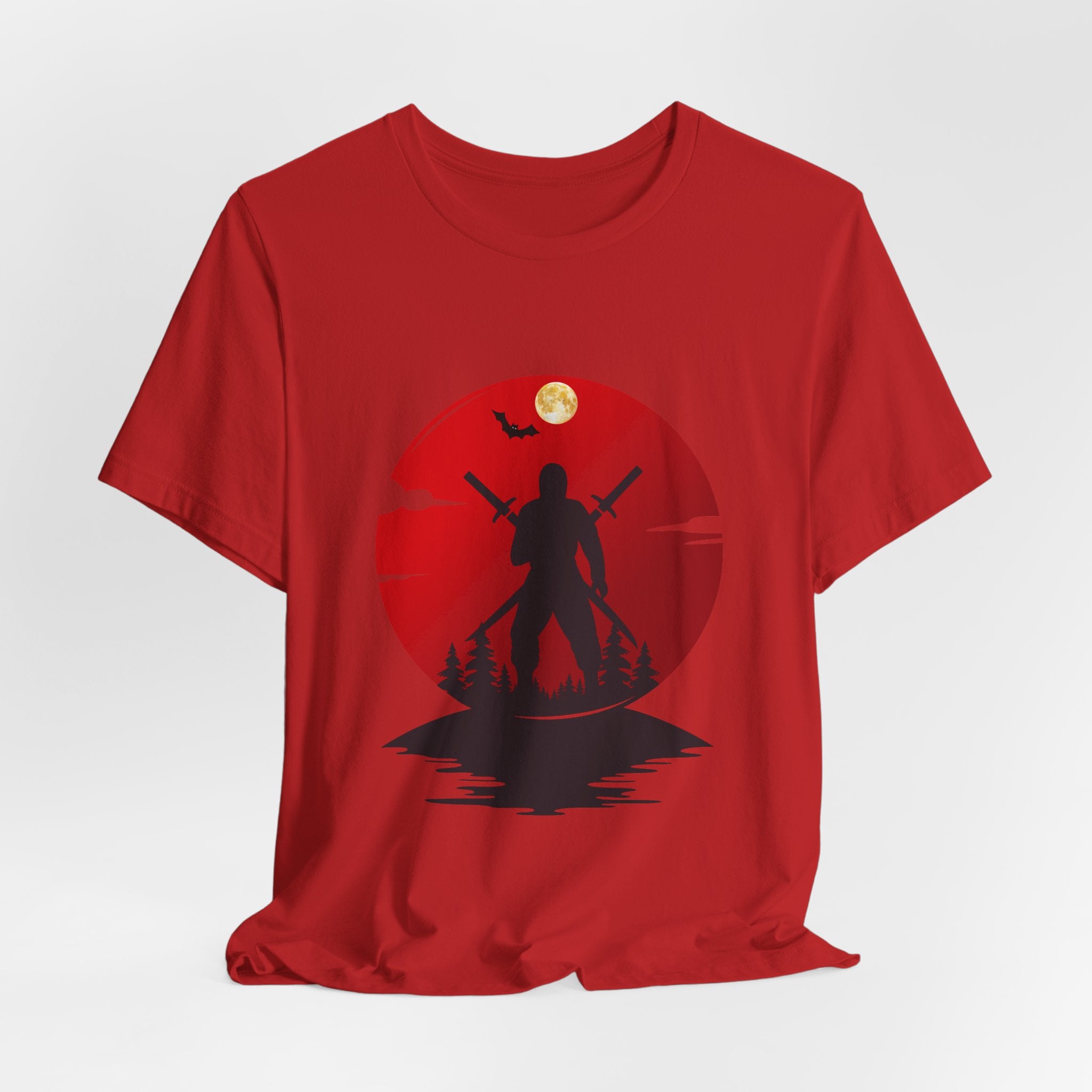 Red t-shirt with a silhouette design of a person holding a staff against a red circle with a moon and bats.
