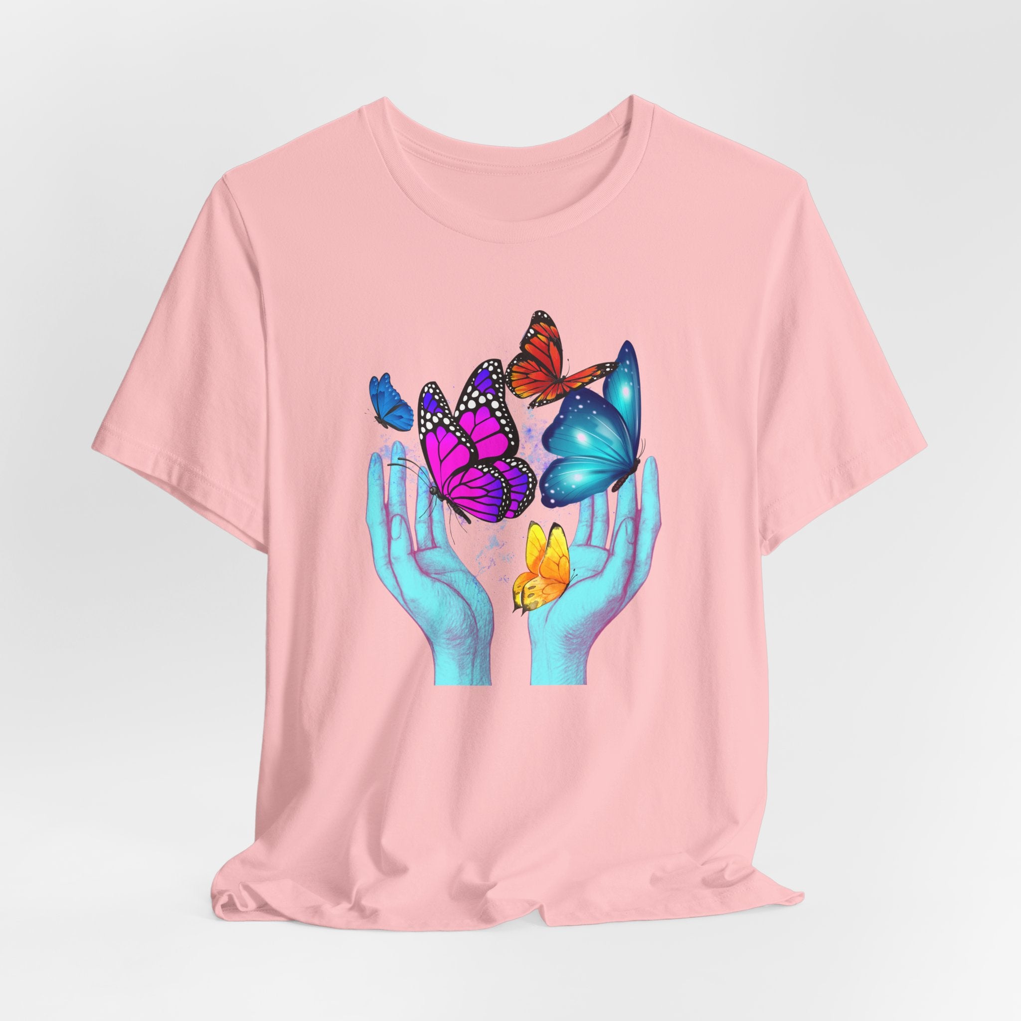 Pink t-shirt with colorful butterfly design on a light gray background