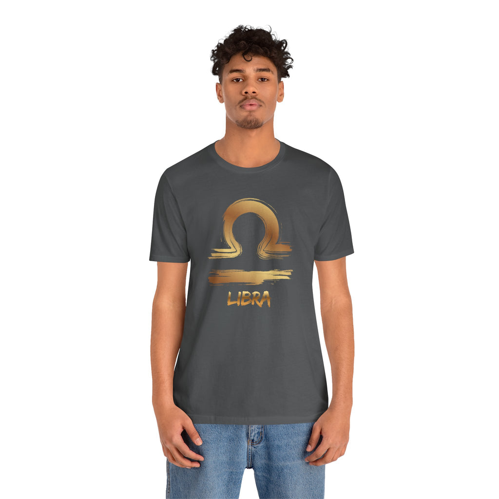 Person wearing a dark gray t-shirt with a gold Libra zodiac symbol on a white background