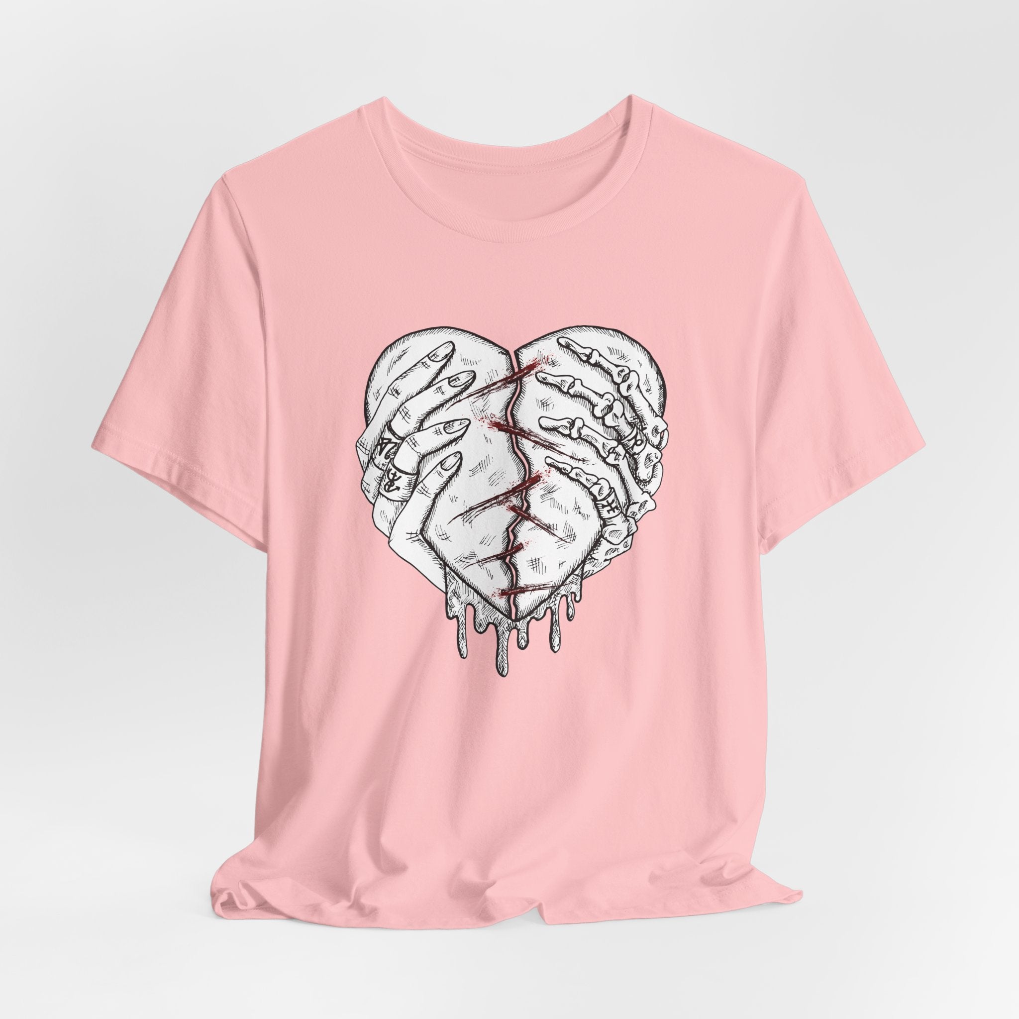 Pink t-shirt with a graphic of a broken heart design on a light gray background