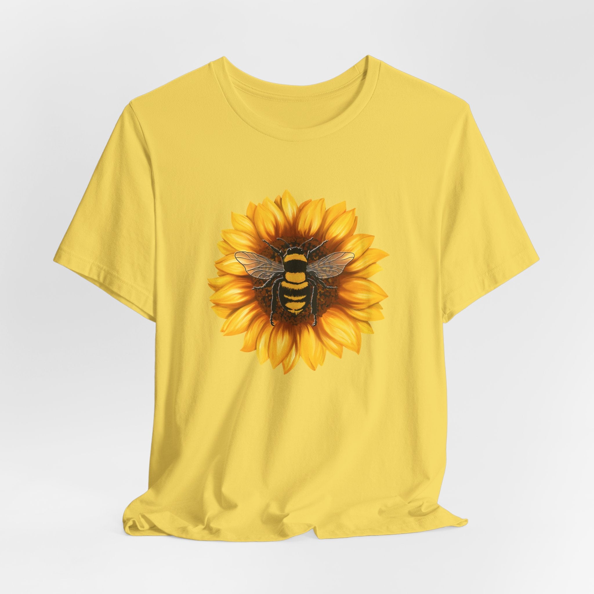 Yellow t-shirt with a sunflower and bee design on a white background