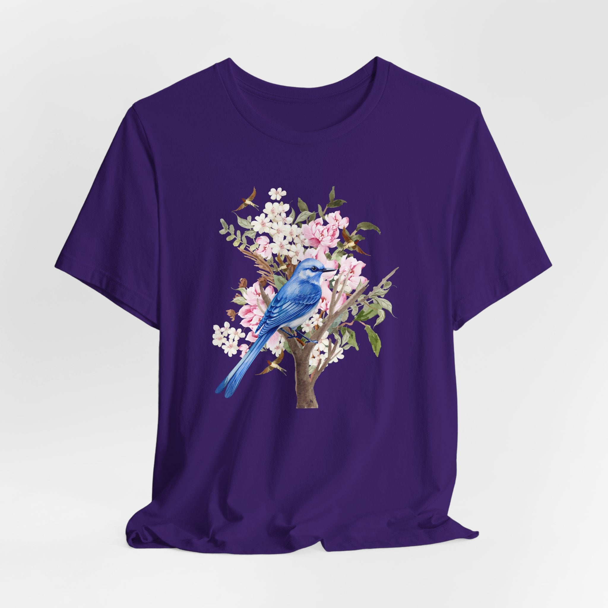 Purple t-shirt with a blue bird and floral design on a white background