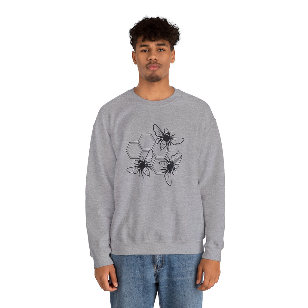 Person wearing a gray sweatshirt with black bee and hexagon pattern on a white background