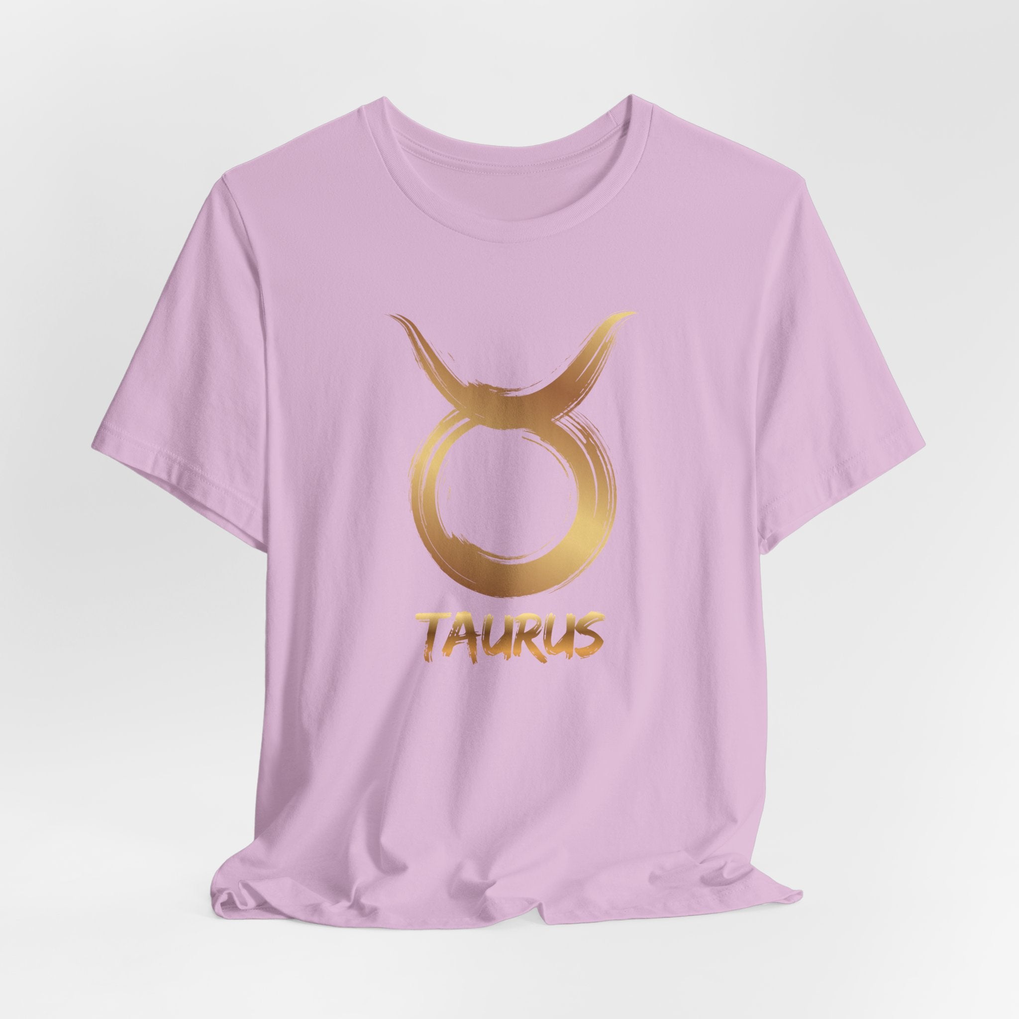 Lavender t-shirt with gold Taurus symbol and text on a light gray background