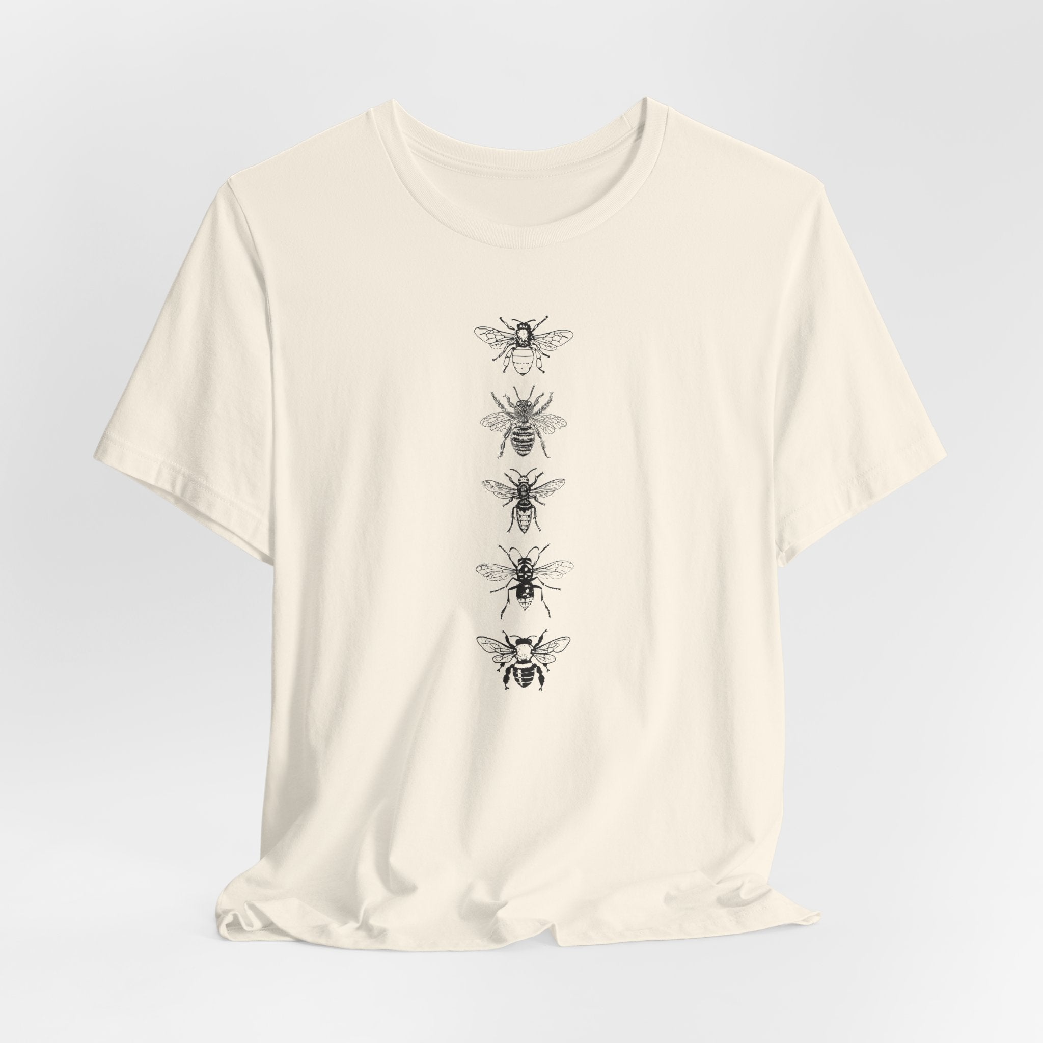 Beige t-shirt with black bee illustrations on a light gray background