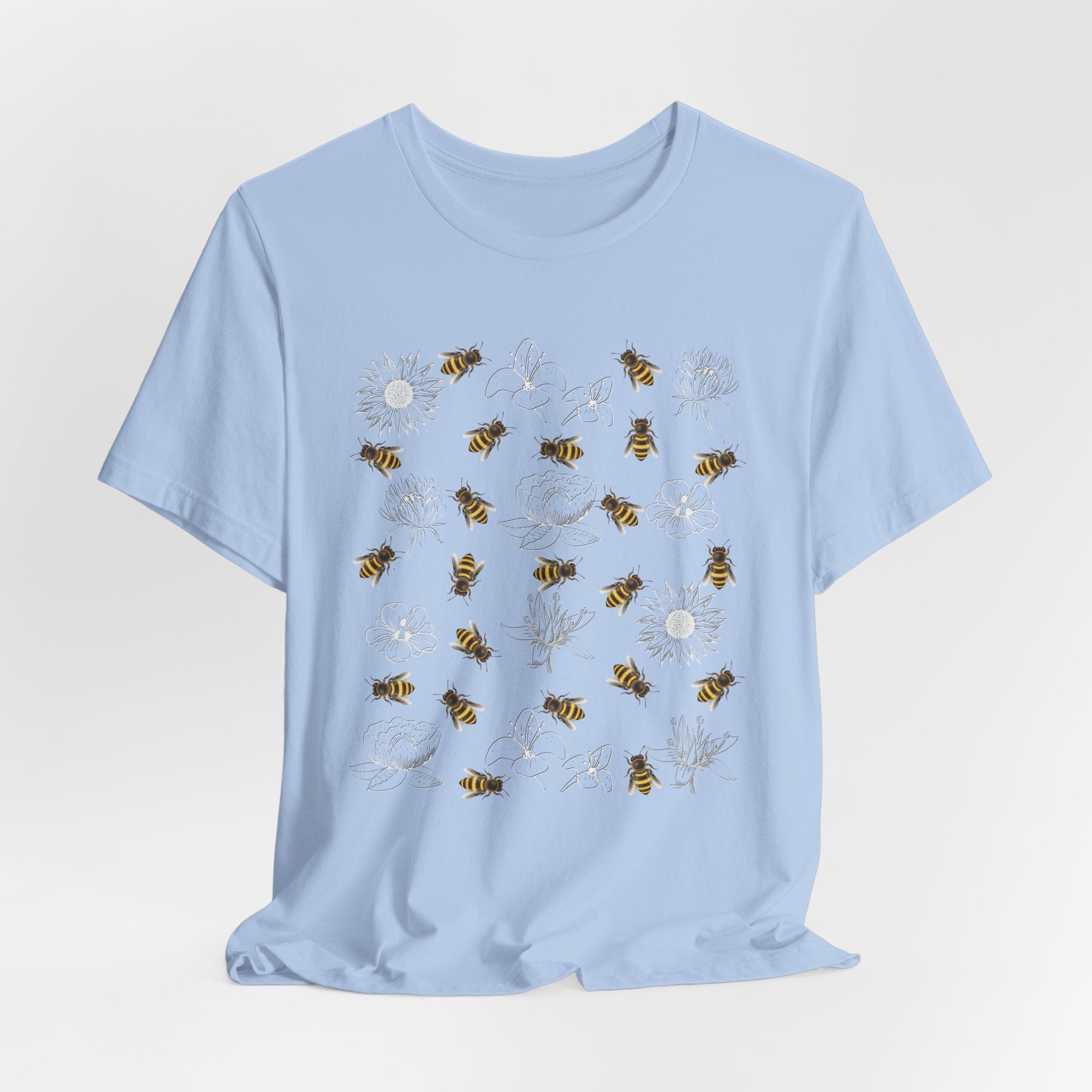 Light blue t-shirt with bee and flower pattern on a light gray background