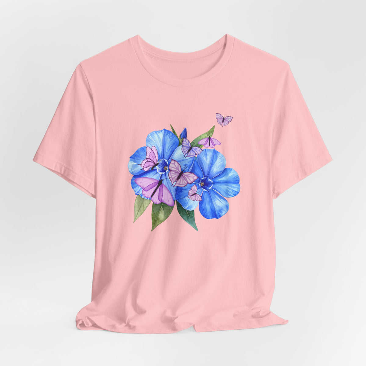Pink t-shirt with blue floral design on a light gray background