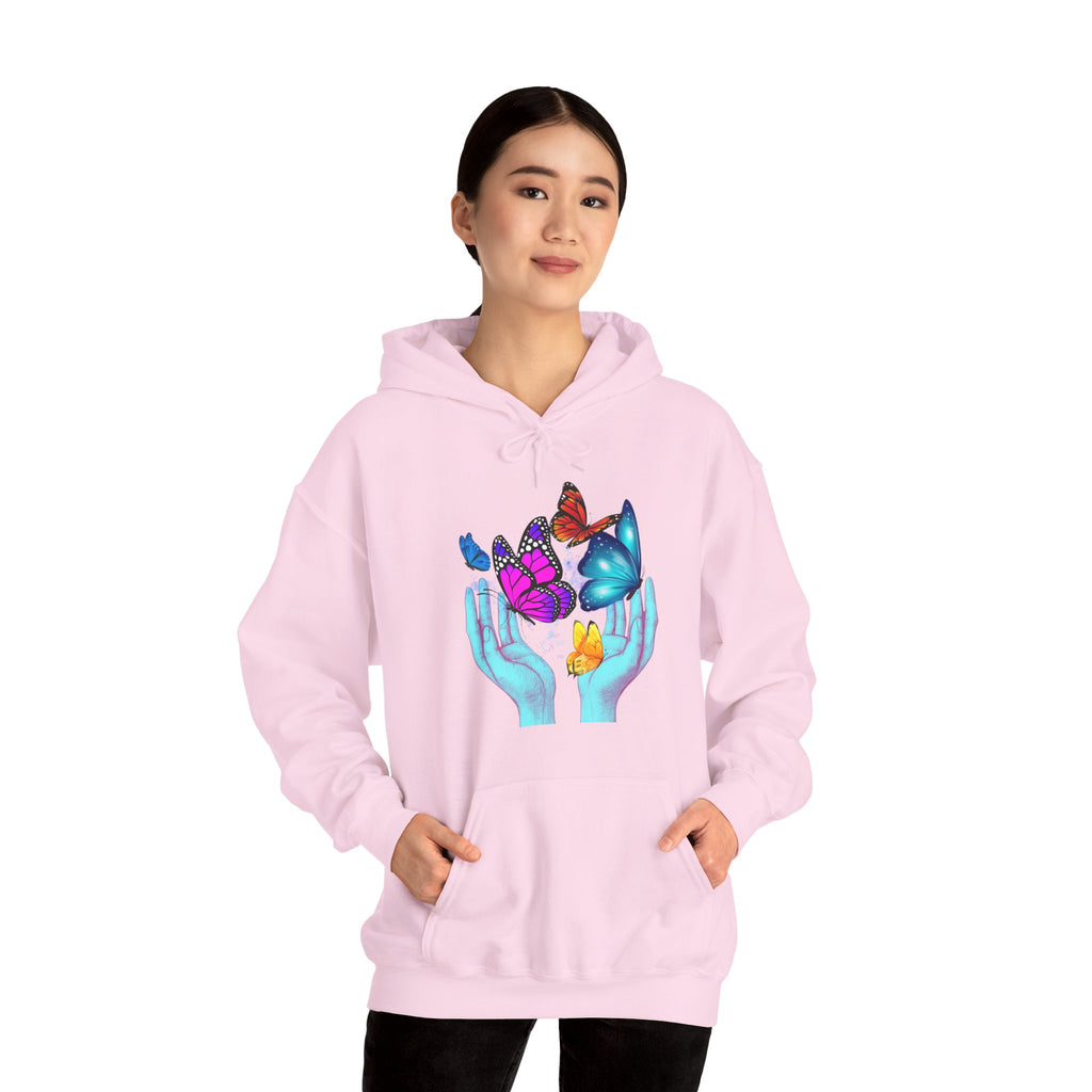 Person wearing a pink hoodie with a colorful design of hands holding butterflies on a white background