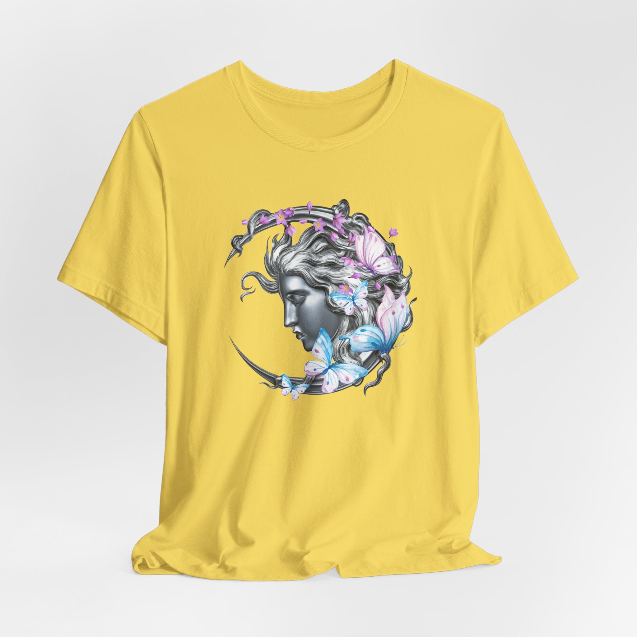 Yellow t-shirt with a graphic design of a woman's face with flowers and butterflies on a white background