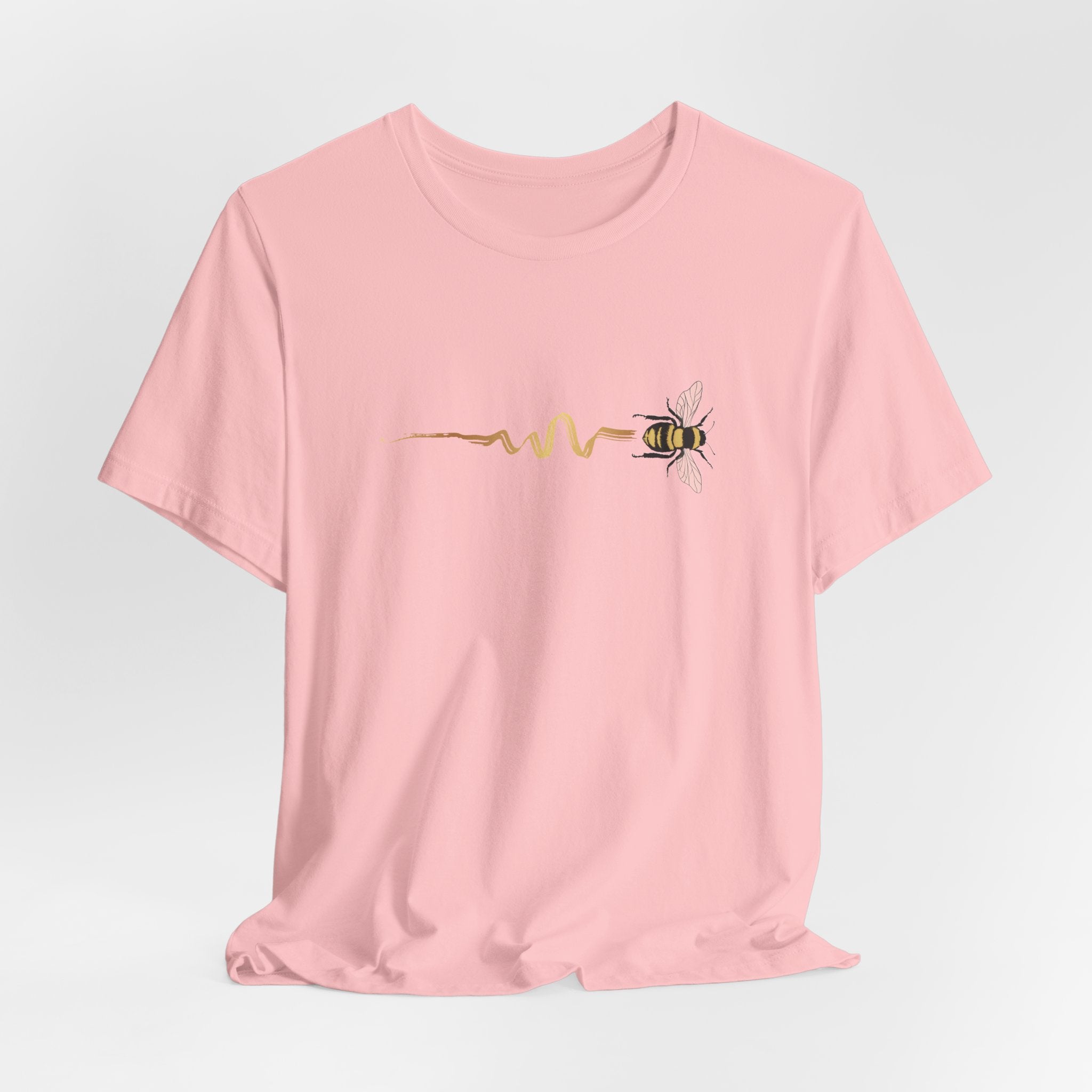 Pink t-shirt with a bee design on a light gray background