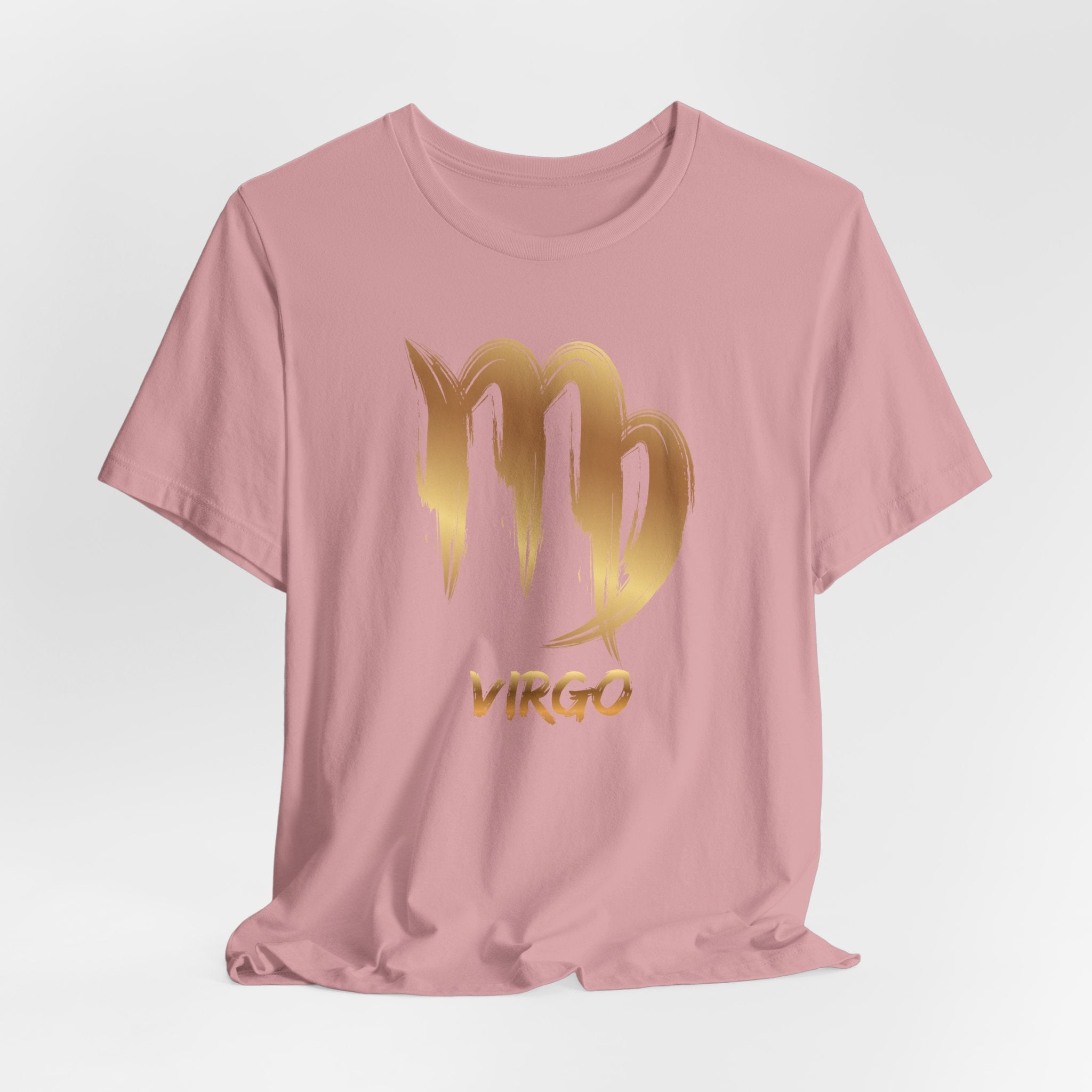 Pink t-shirt with gold Virgo zodiac sign design on a light gray background