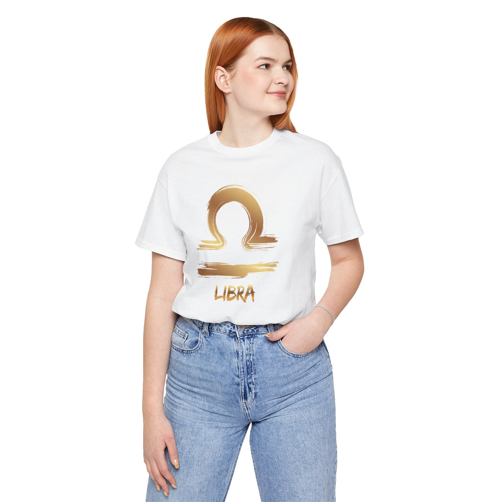 Person wearing a white t-shirt with a gold Libra zodiac symbol on a white background