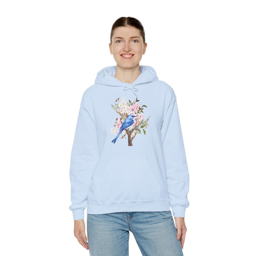 Person wearing a light blue hoodie with a blue bird and floral design on a white background