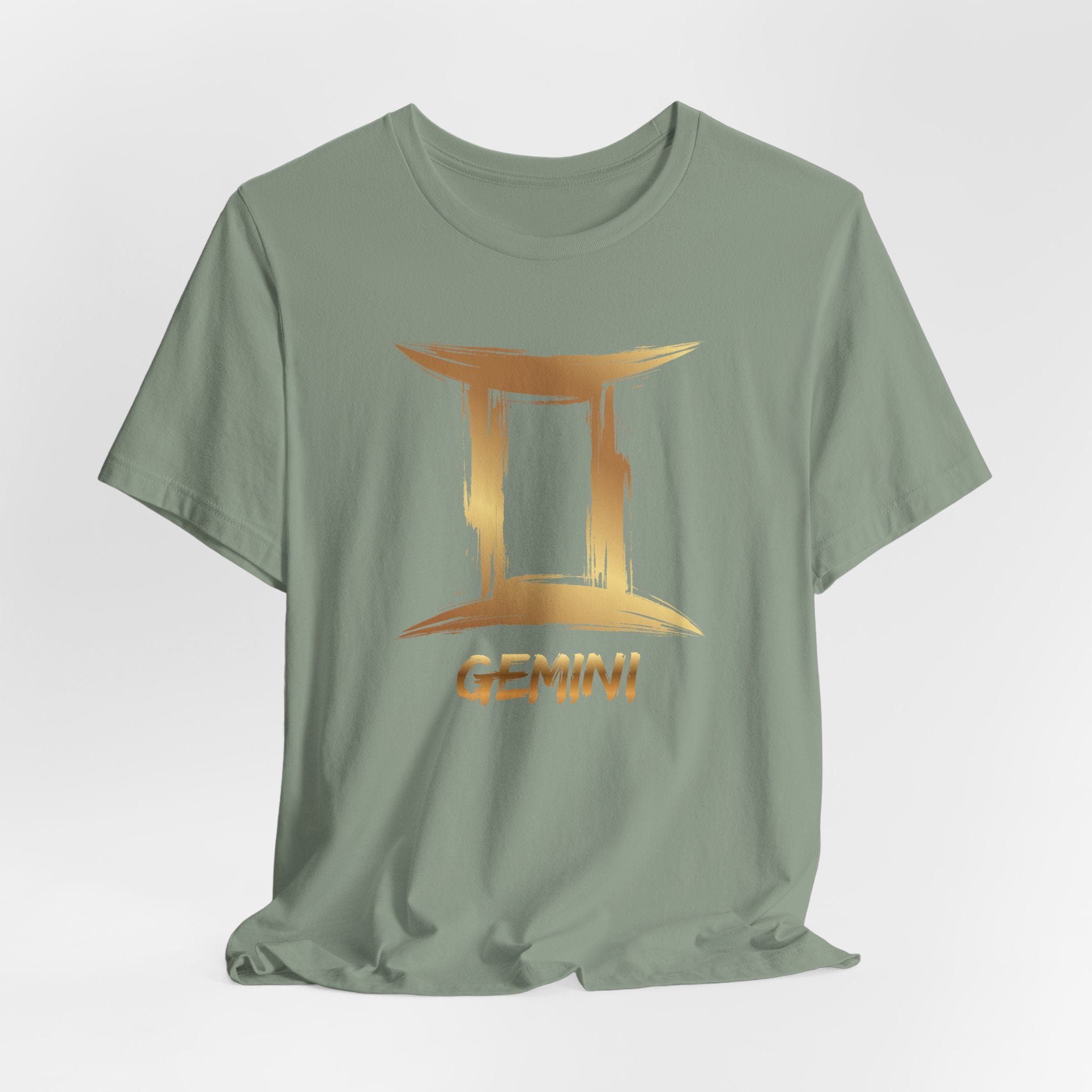 Green t-shirt with gold Gemini zodiac sign design on a light gray background