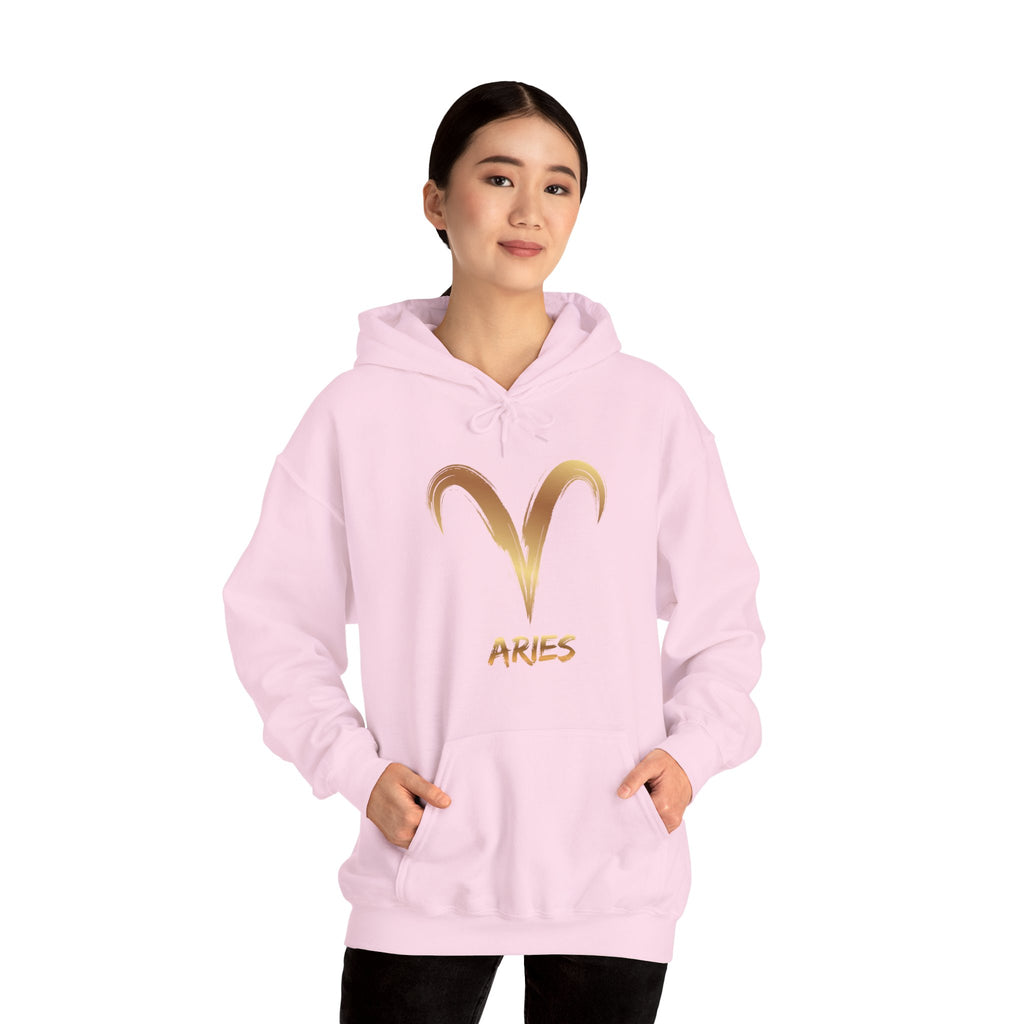 Person wearing a pink hoodie with gold Aries symbol and text on a white background
