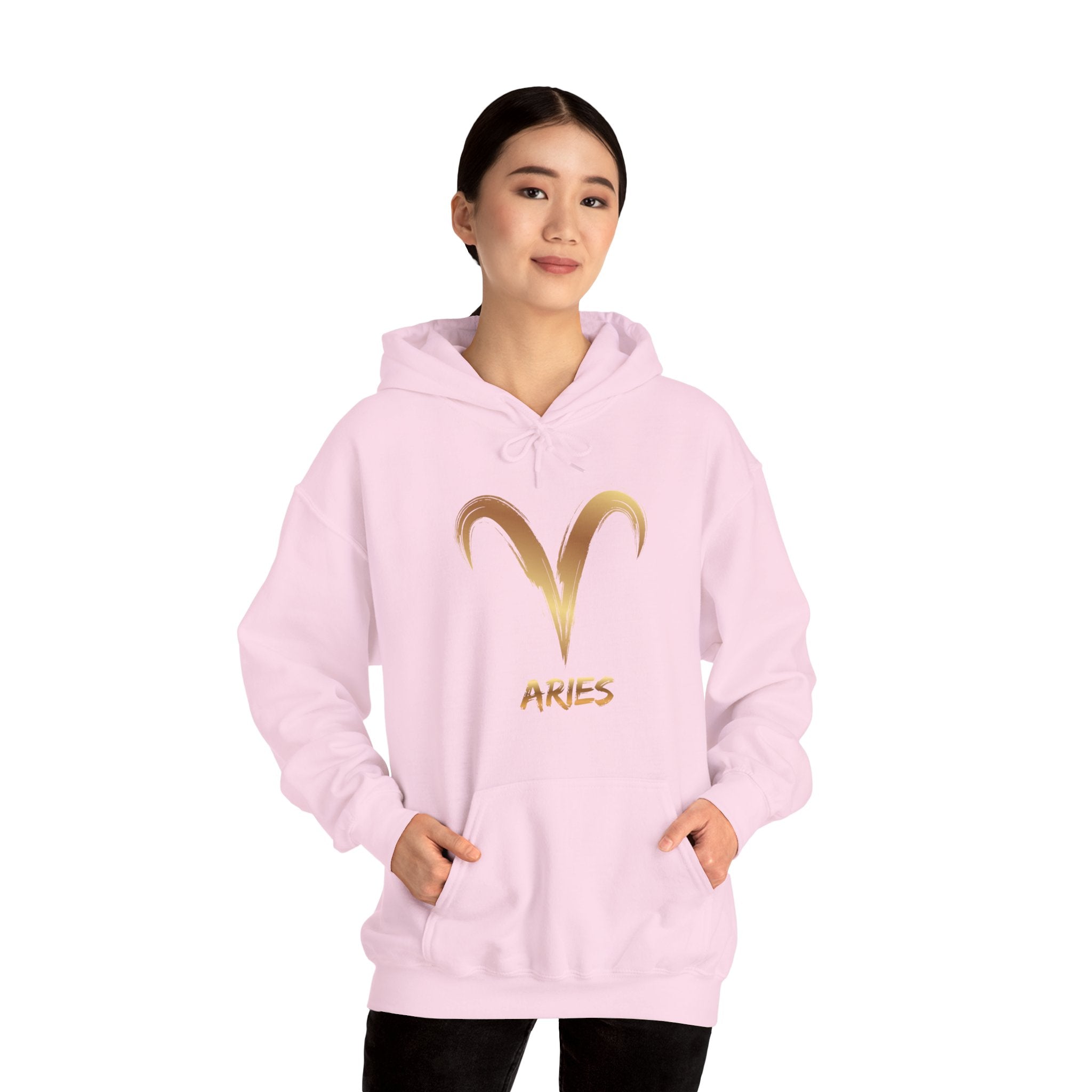 Person wearing a pink hoodie with gold Aries symbol and text on a white background