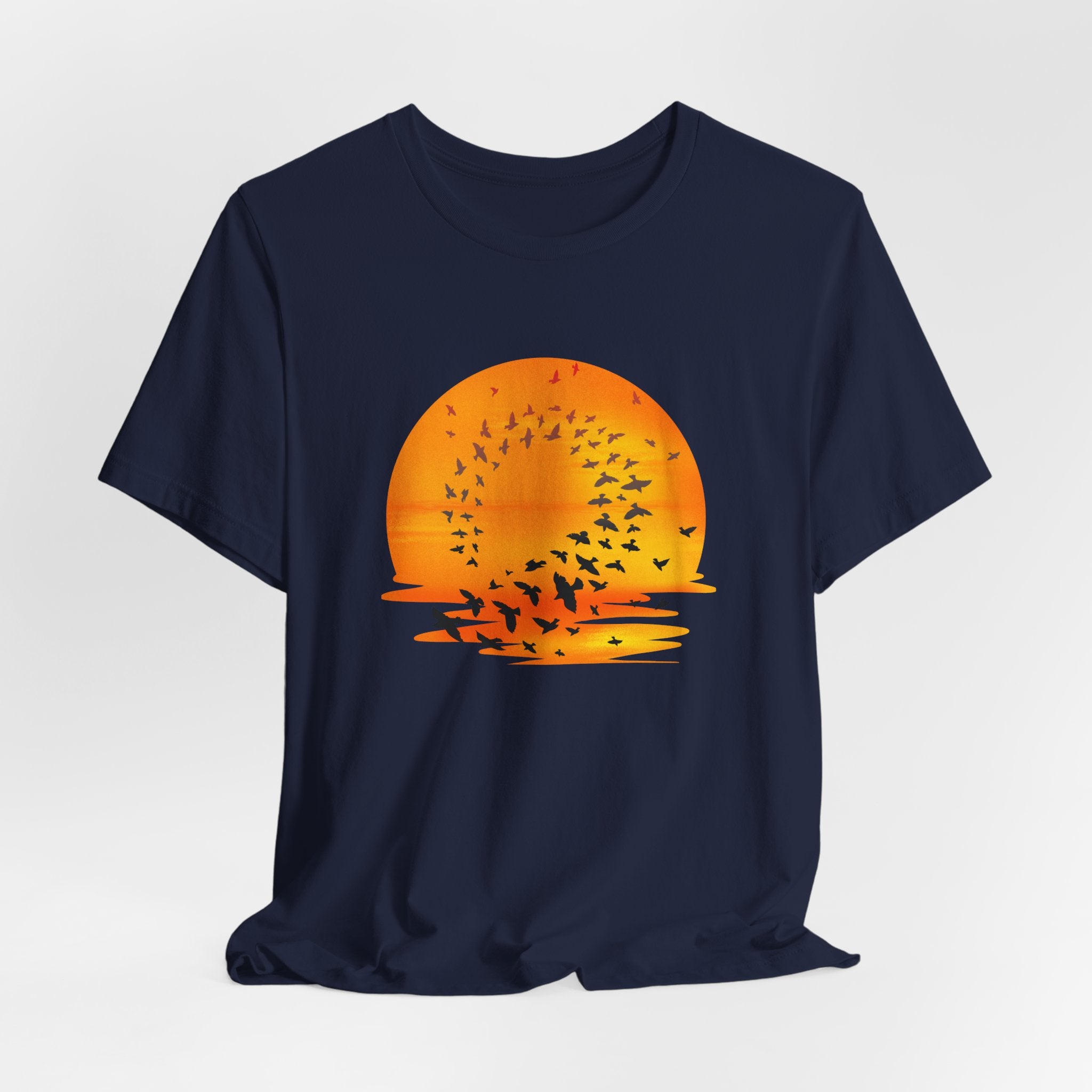 Navy blue t-shirt with an orange sunset and bird design on a light gray background