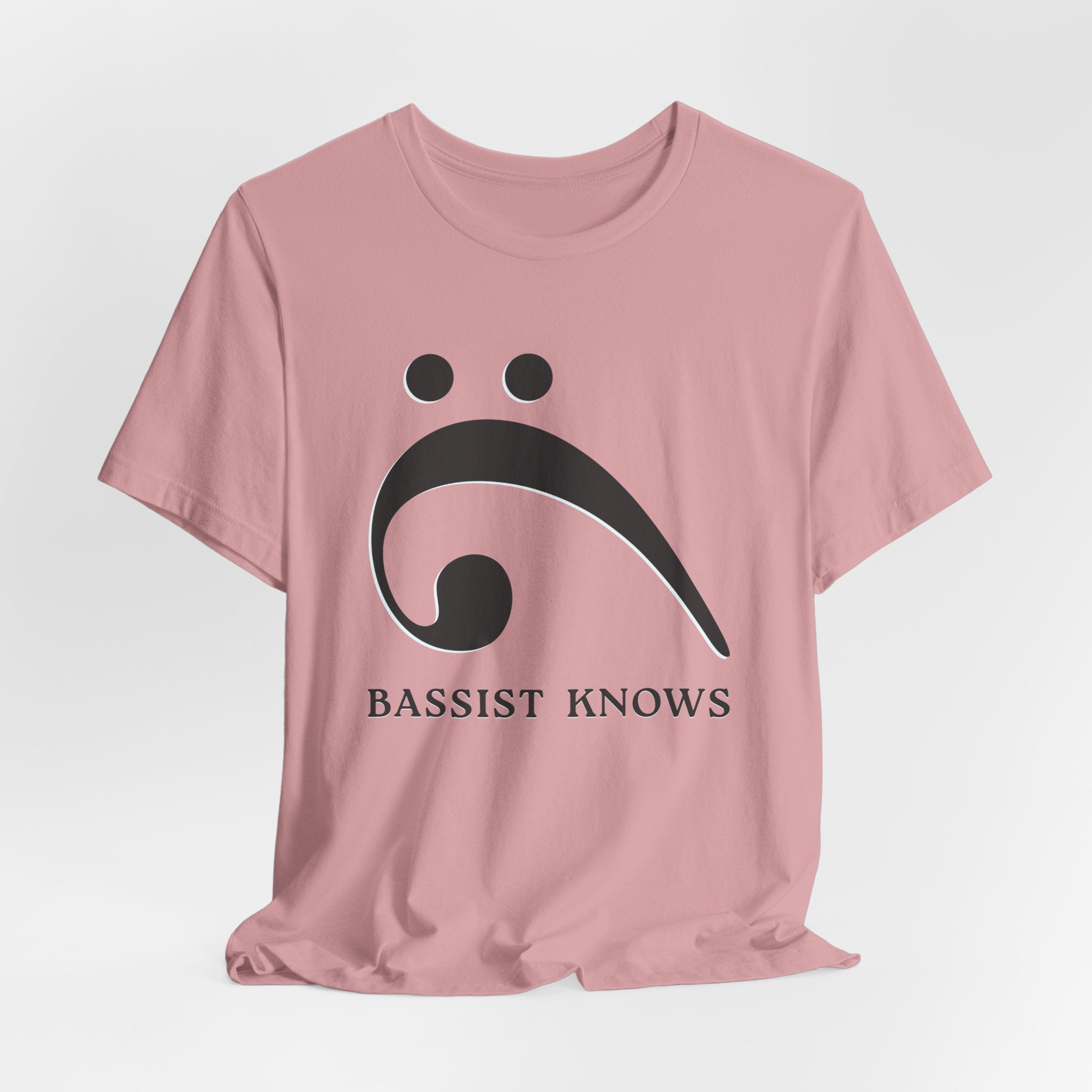 Pink t-shirt with black bass clef and 'Bassist Knows' text on a light gray background