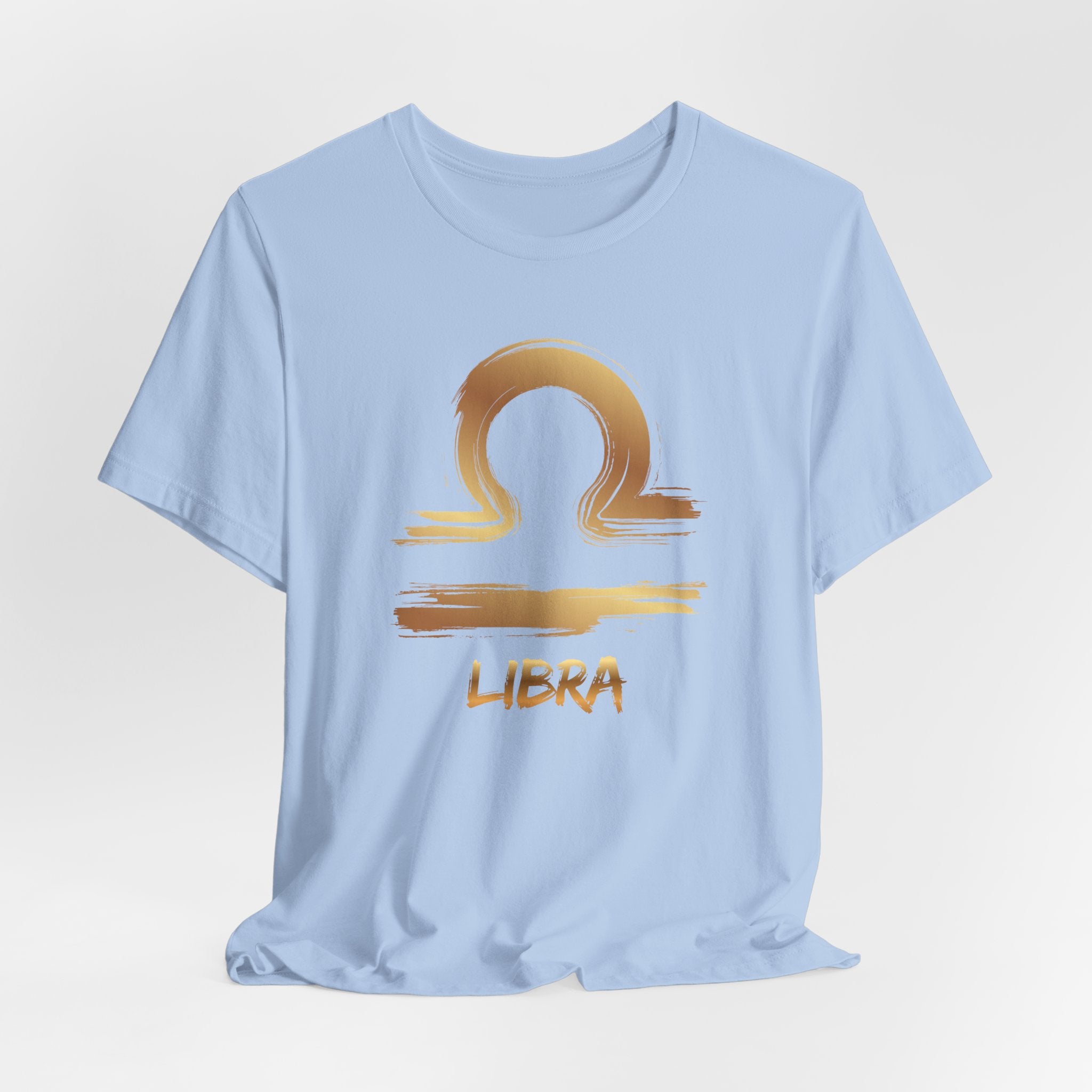Light blue t-shirt with gold Libra zodiac sign design on a light gray background