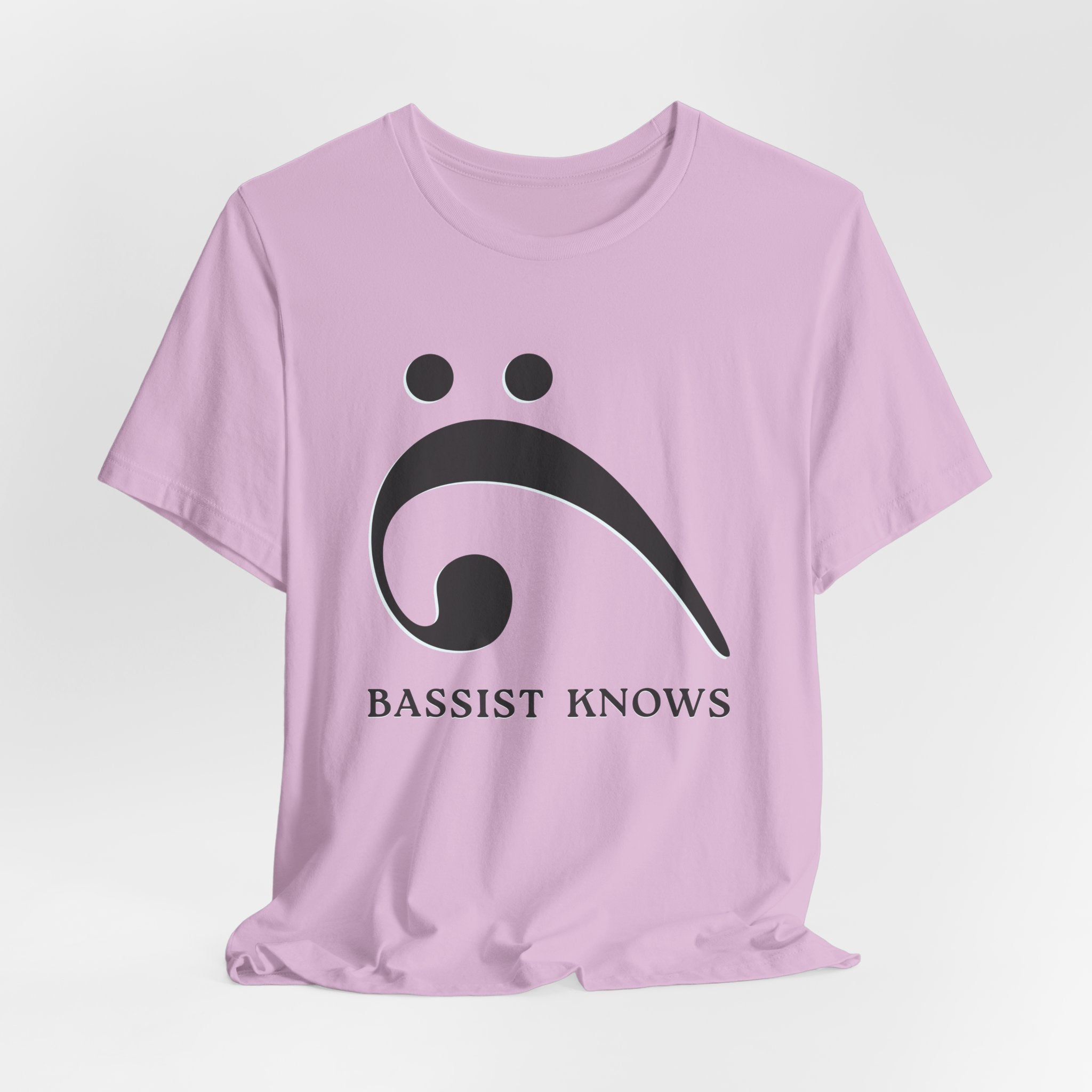 Pink t-shirt with black bass clef and 'Bassist Knows' text on a light gray background