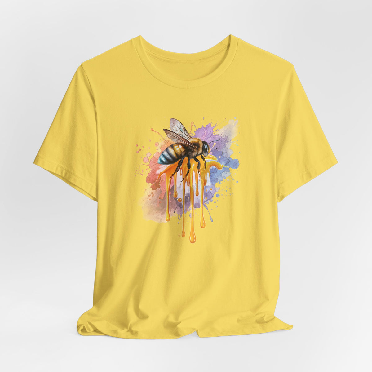Yellow t-shirt with a bee and abstract design on a light gray background