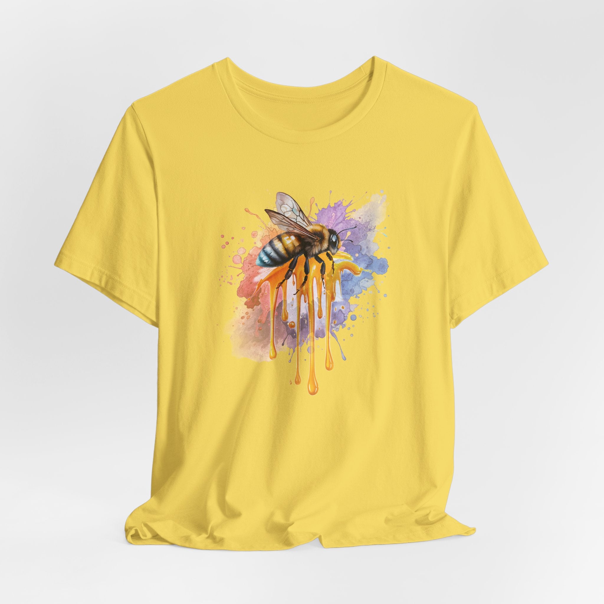 Yellow t-shirt with a bee and abstract design on a light gray background