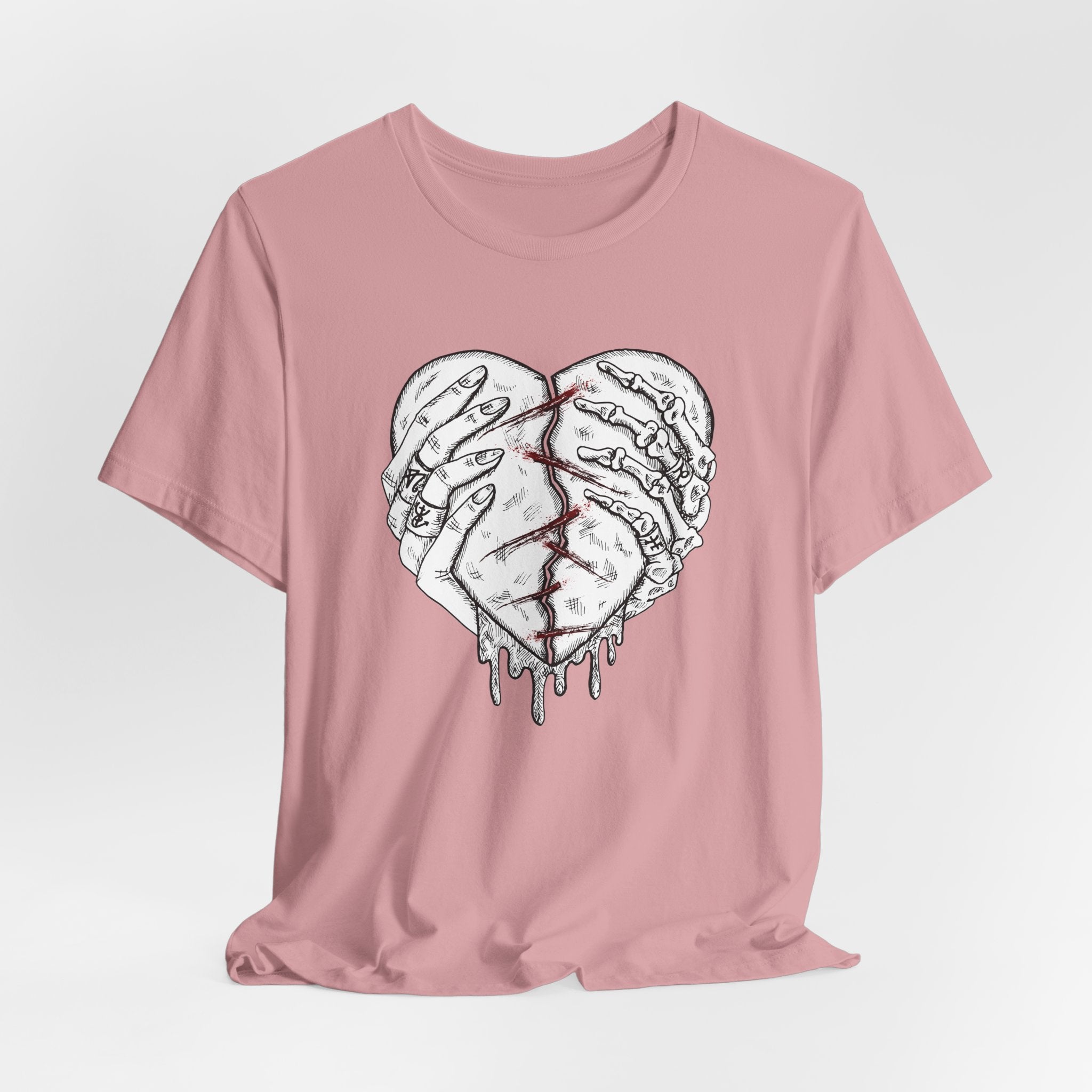 Pink t-shirt with a graphic of a broken heart design on a light gray background