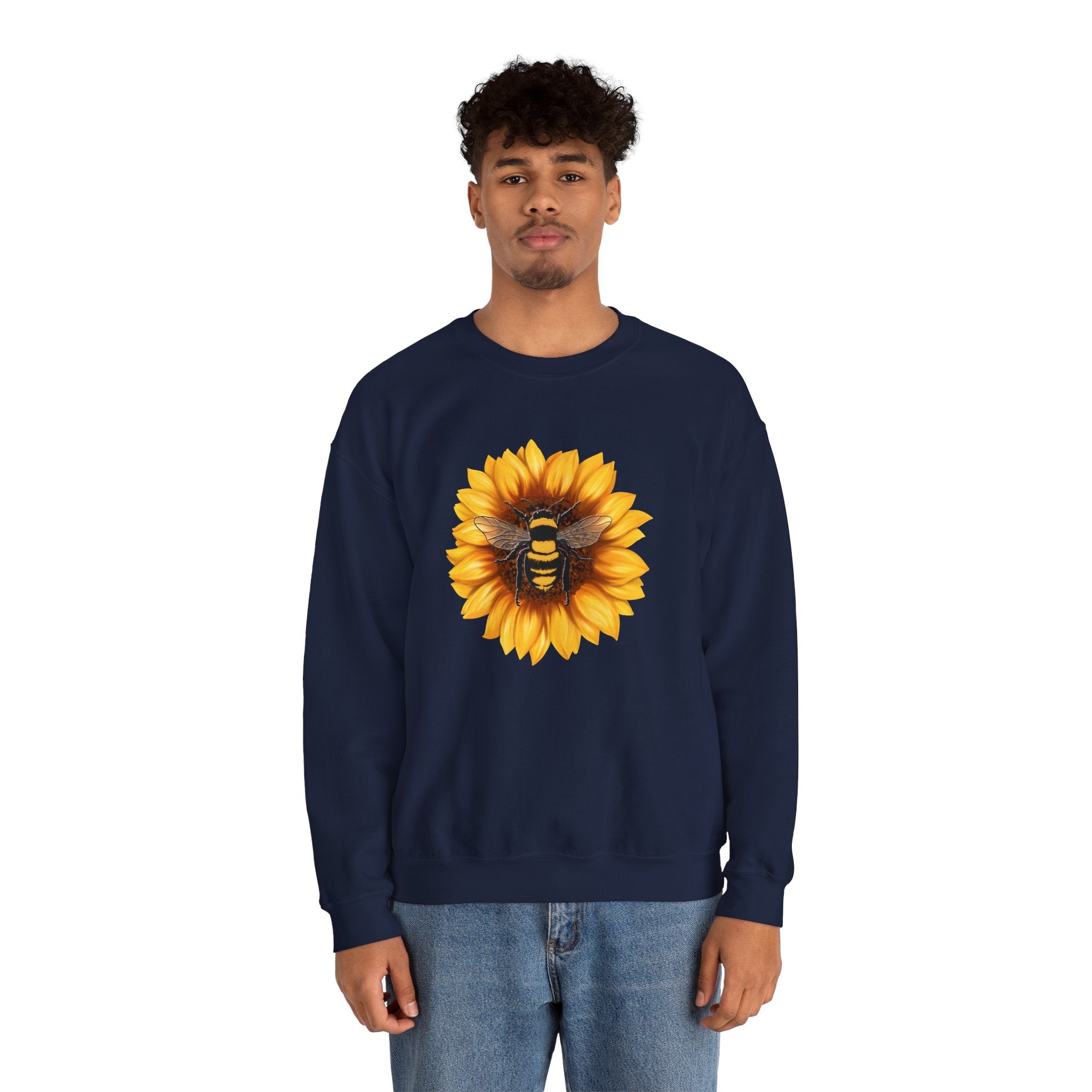Person wearing a navy sweatshirt with a sunflower and bee design on a white background