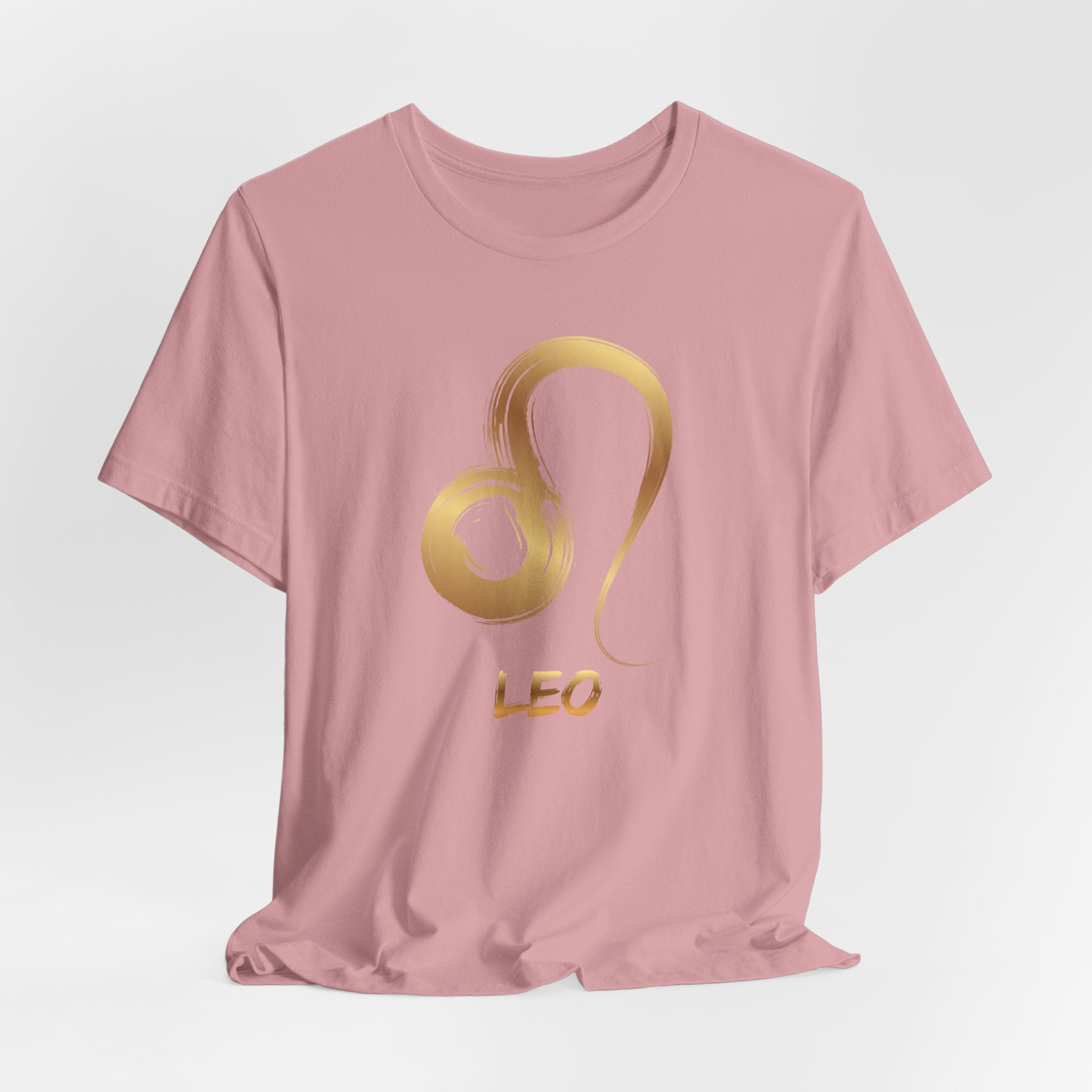 Pink t-shirt with gold Leo zodiac symbol on a light gray background