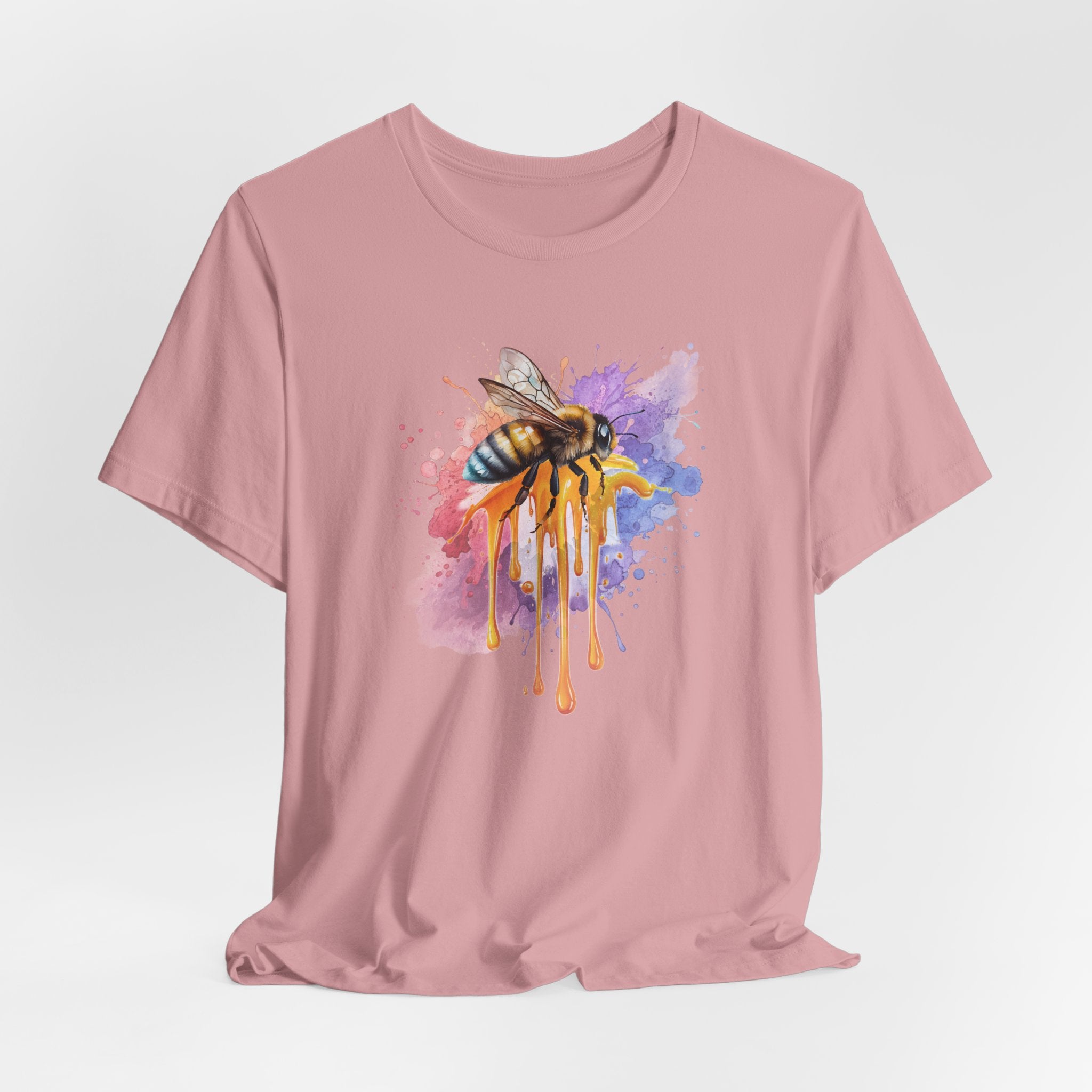 Pink t-shirt with a colorful bee graphic on a light gray background