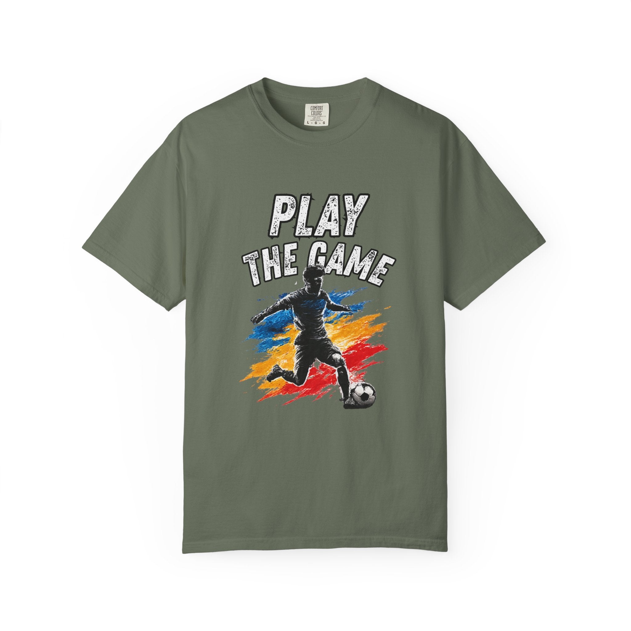 An olive green short-sleeve t-shirt with a graphic on the front showing a soccer player kicking a ball with the text 'PLAY THE GAME' above, set against a plain white background.