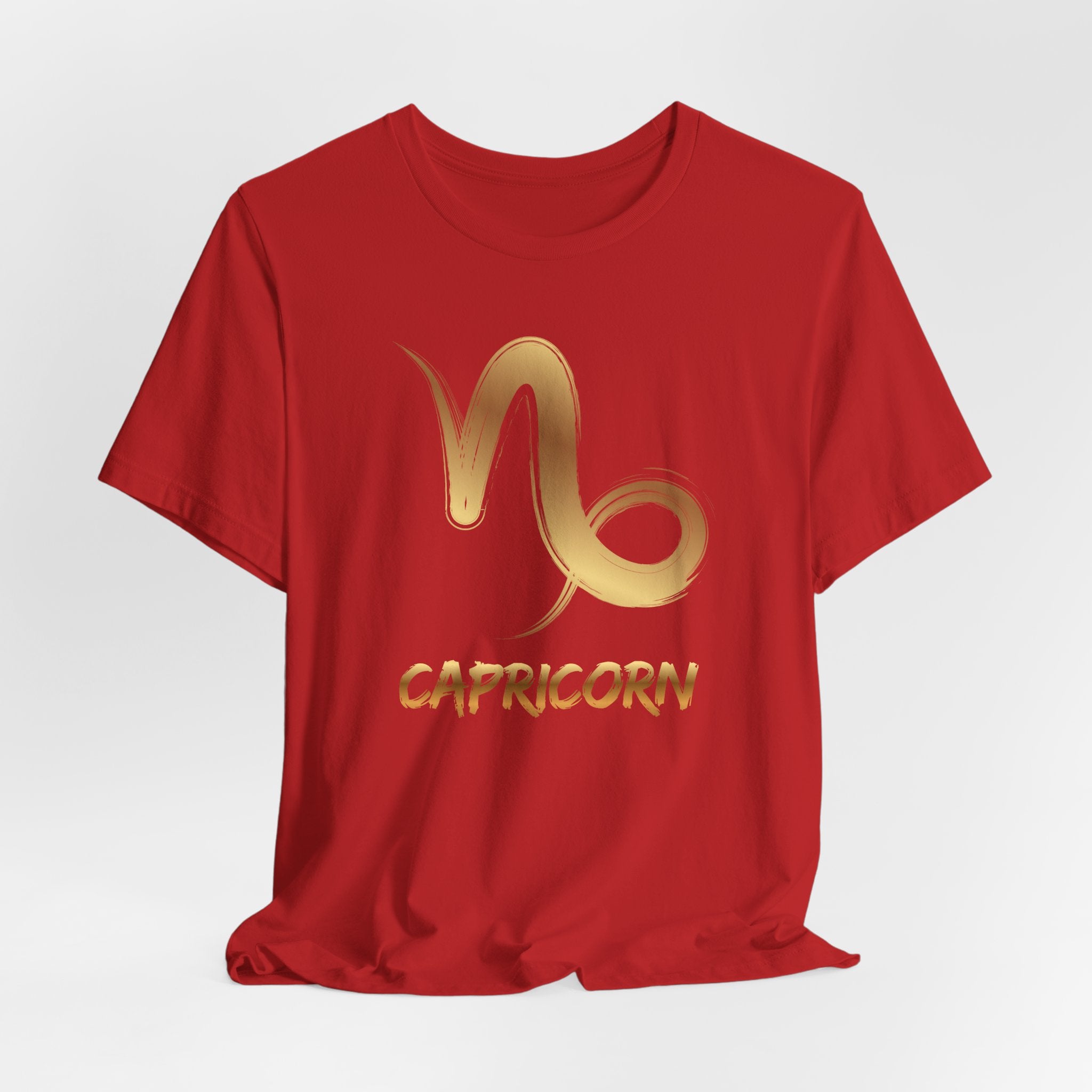 Red t-shirt with gold Capricorn zodiac symbol on a white background
