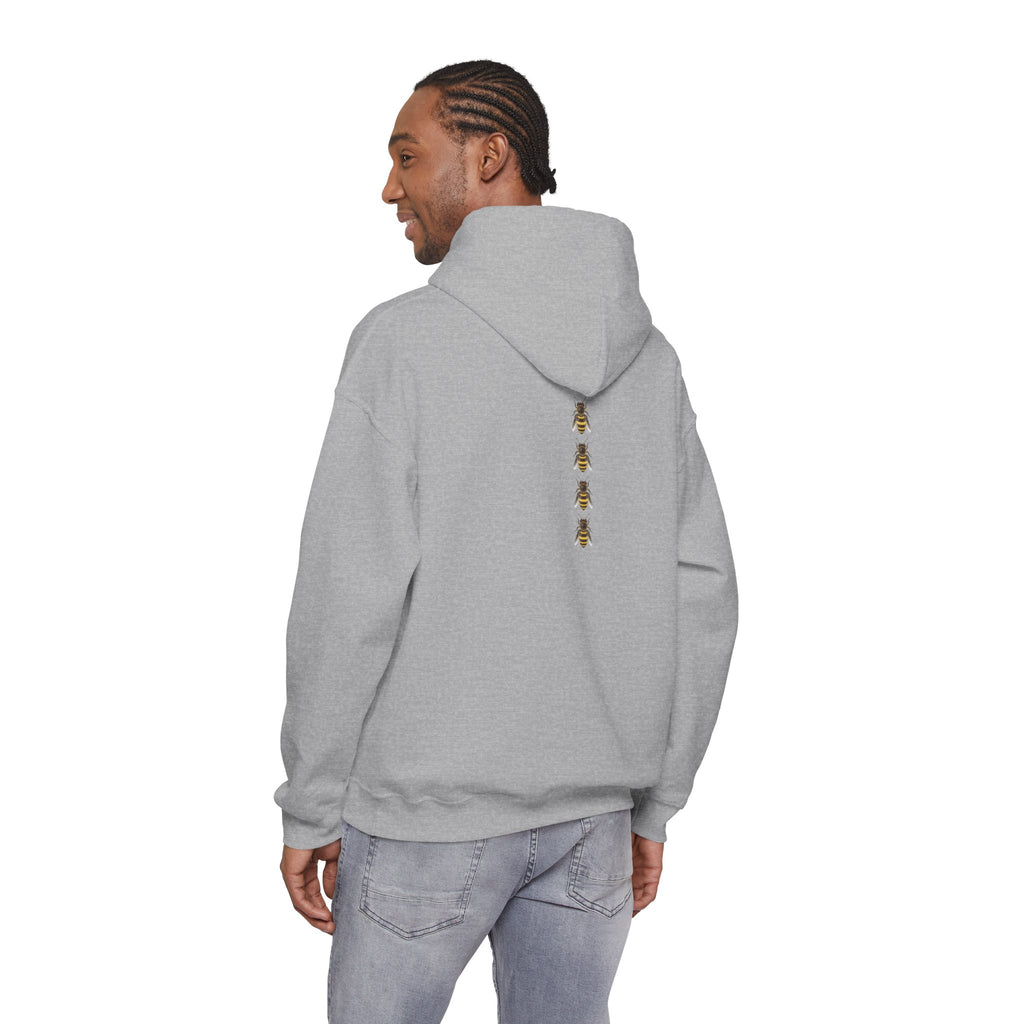 Person wearing a gray hoodie with a bee logo on the back, standing against a white background