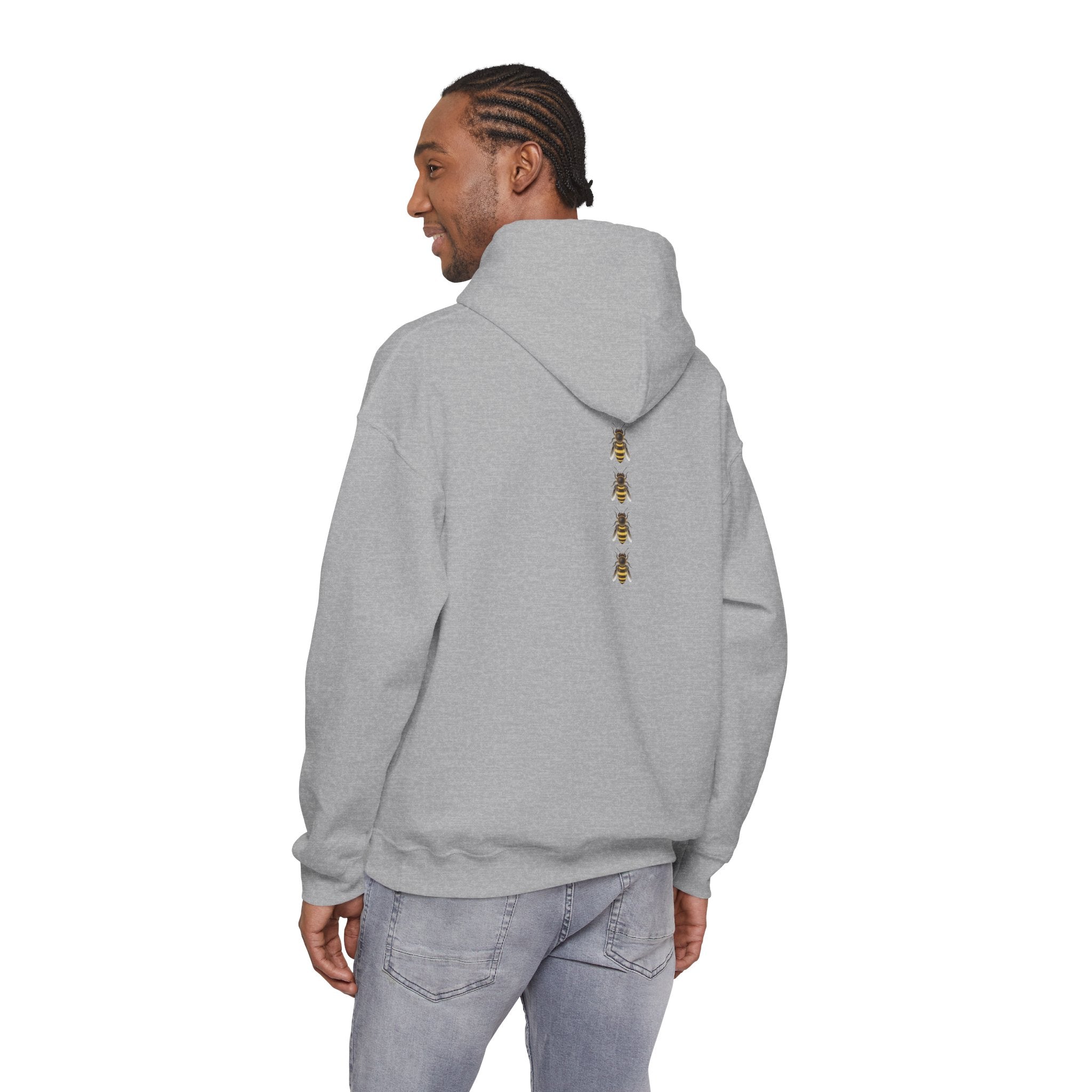 Person wearing a gray hoodie with a bee logo on the back, standing against a white background