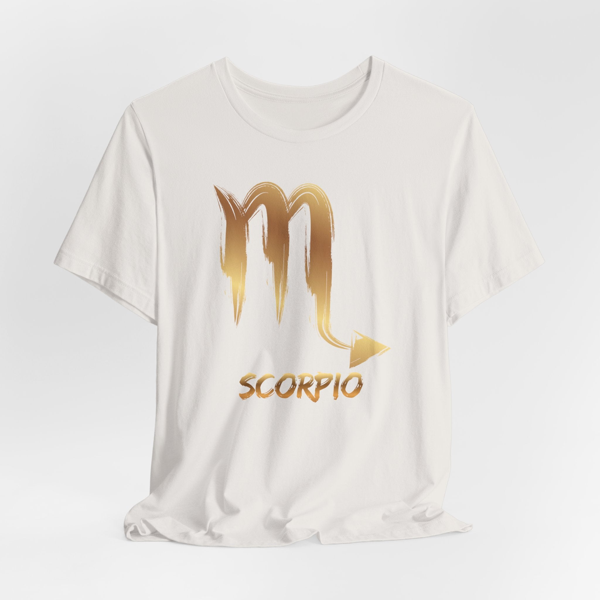 White t-shirt with gold Scorpio zodiac symbol on a light gray background