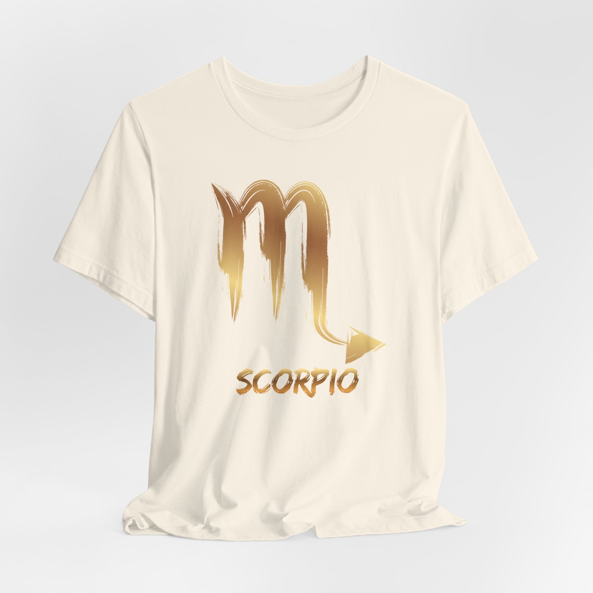White t-shirt with gold Scorpio zodiac symbol on a light gray background