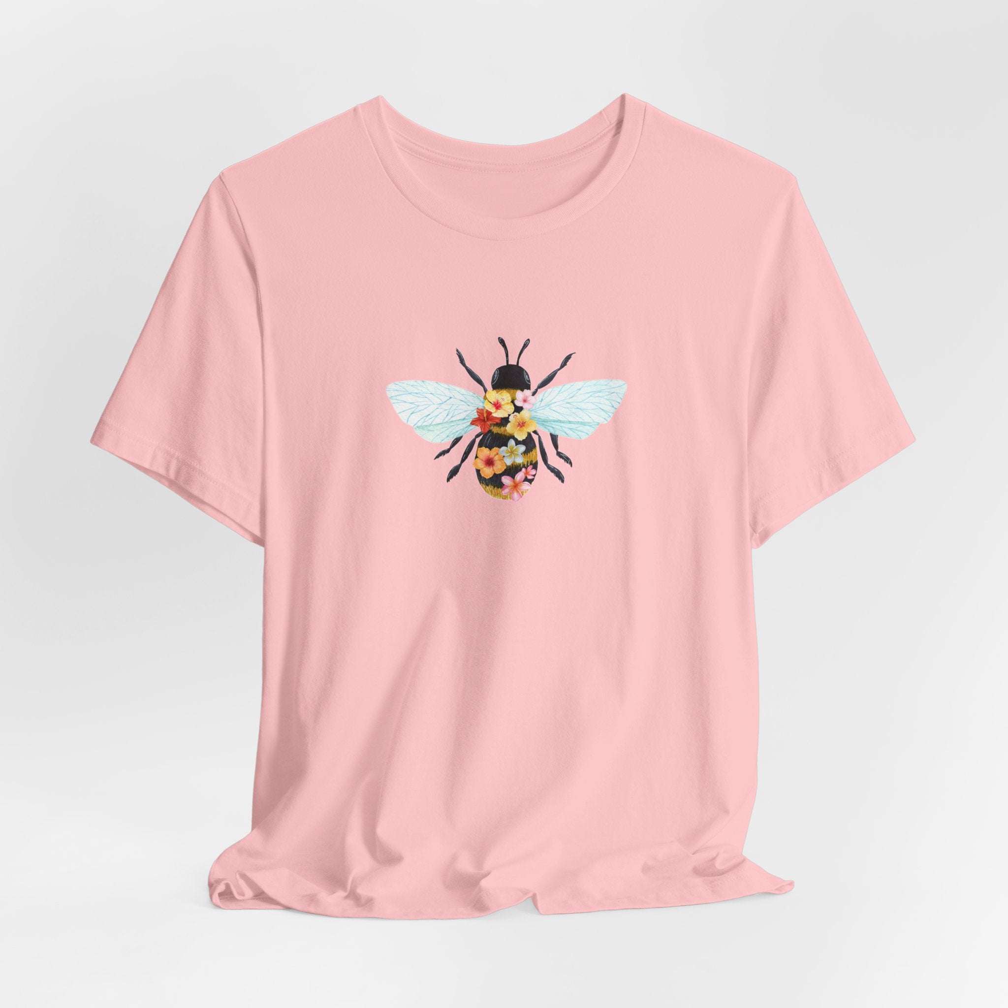 Pink t-shirt with a bee graphic on a light gray background