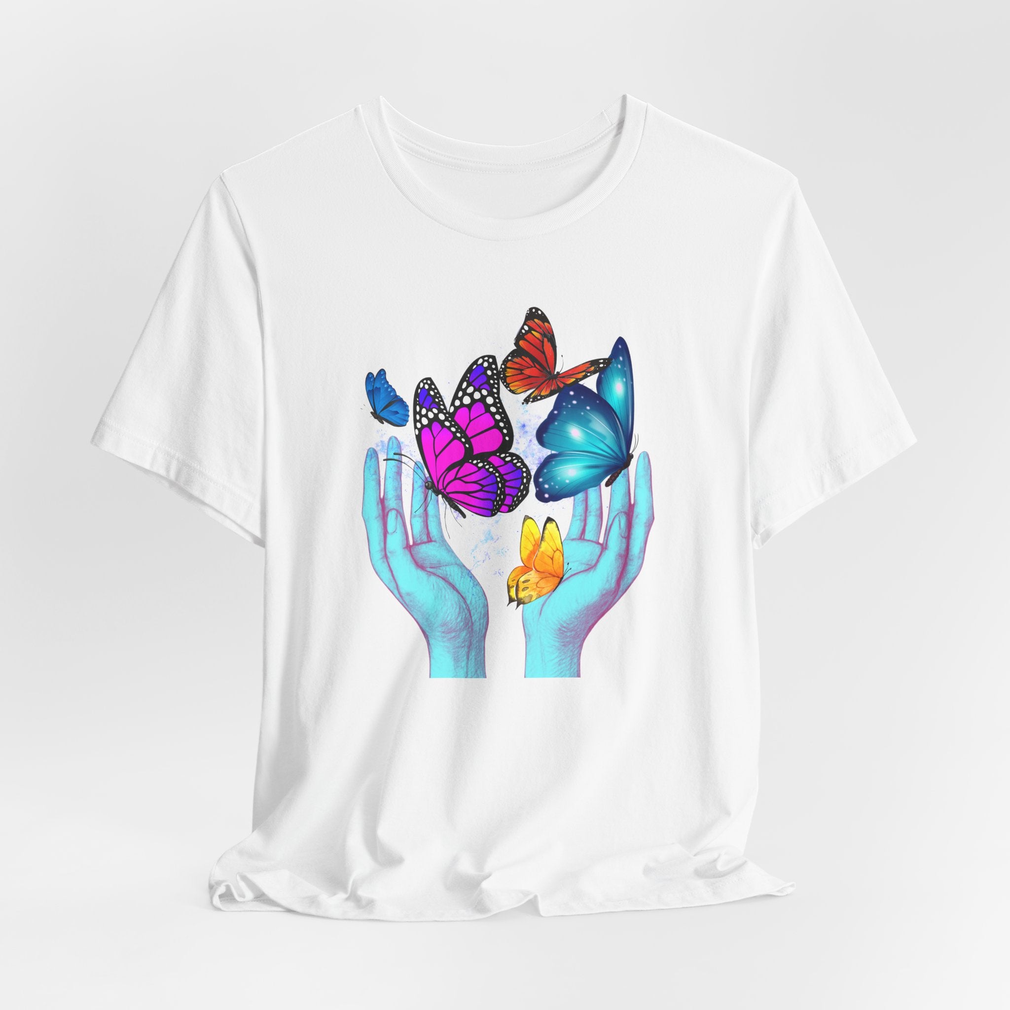 White t-shirt with colorful butterfly design on a plain background