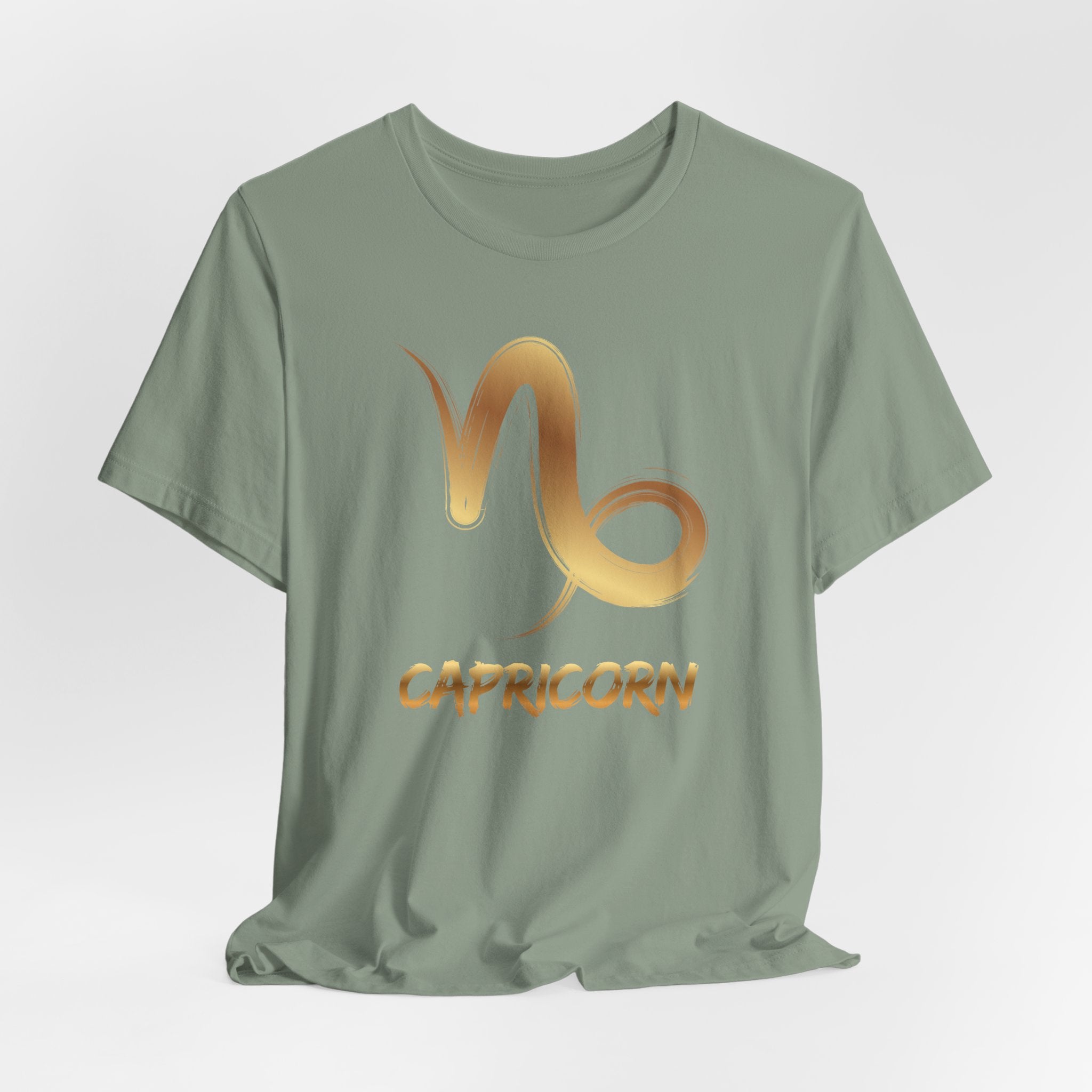 Green t-shirt with Capricorn zodiac symbol in gold on a light gray background