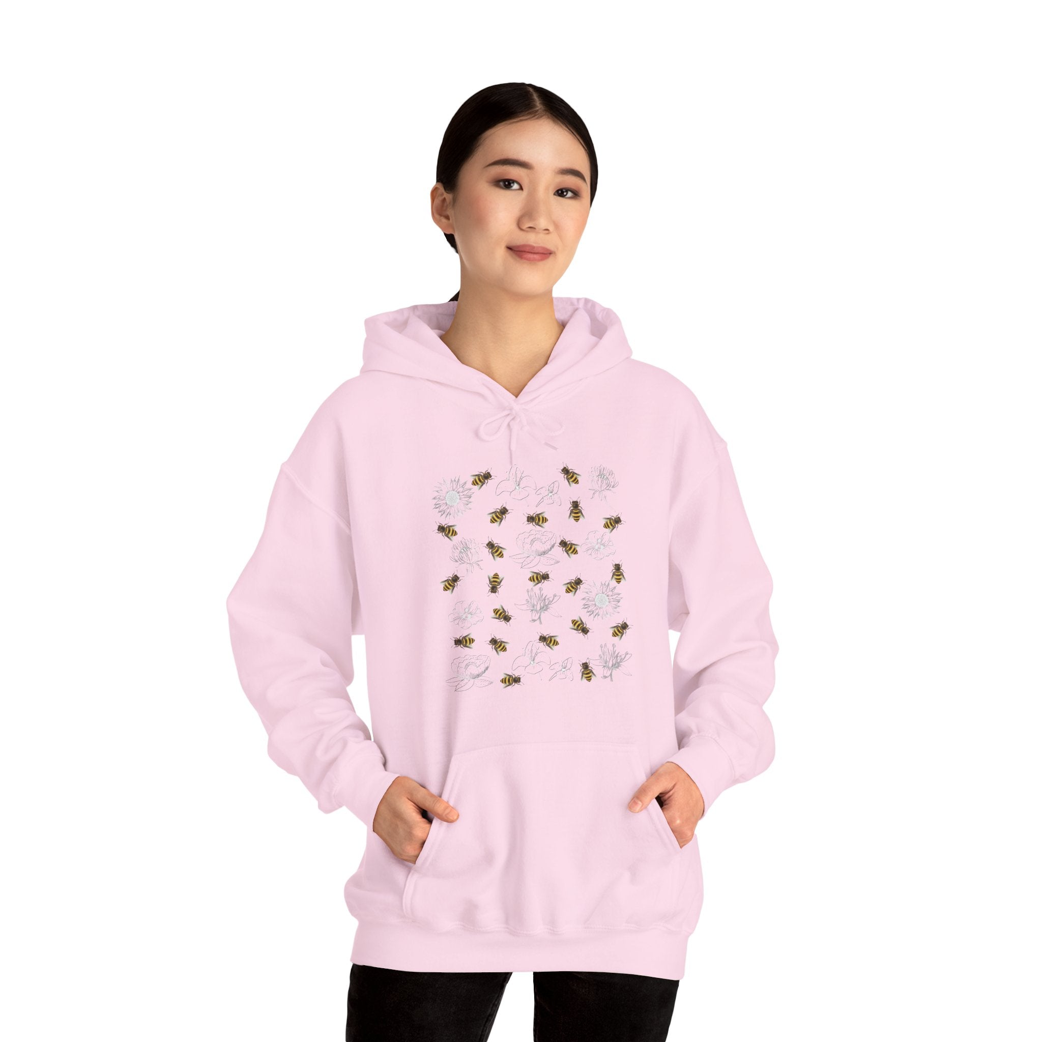 Person wearing a pink hoodie with floral and bee design on a white background