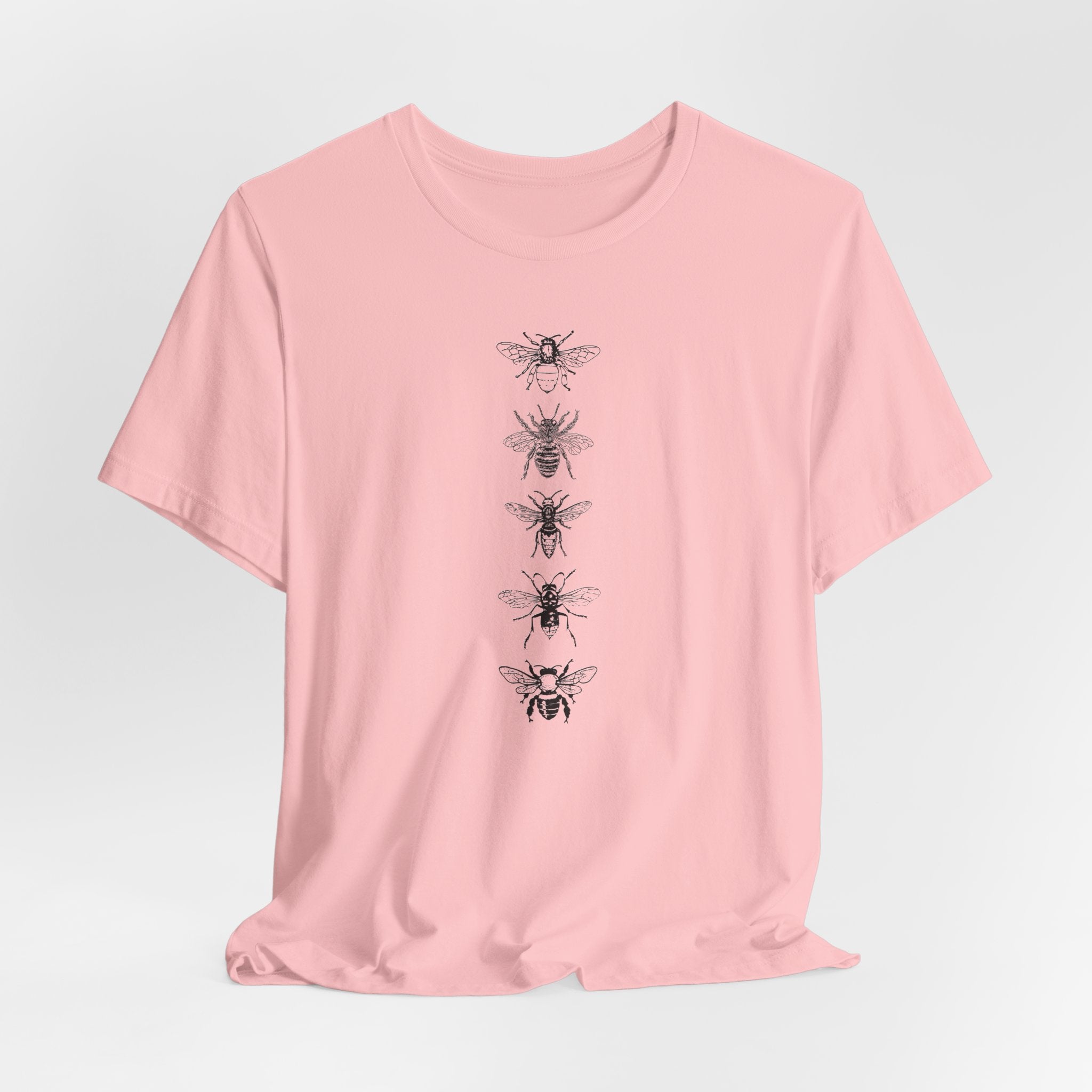 Pink t-shirt with black bee illustrations on a light gray background