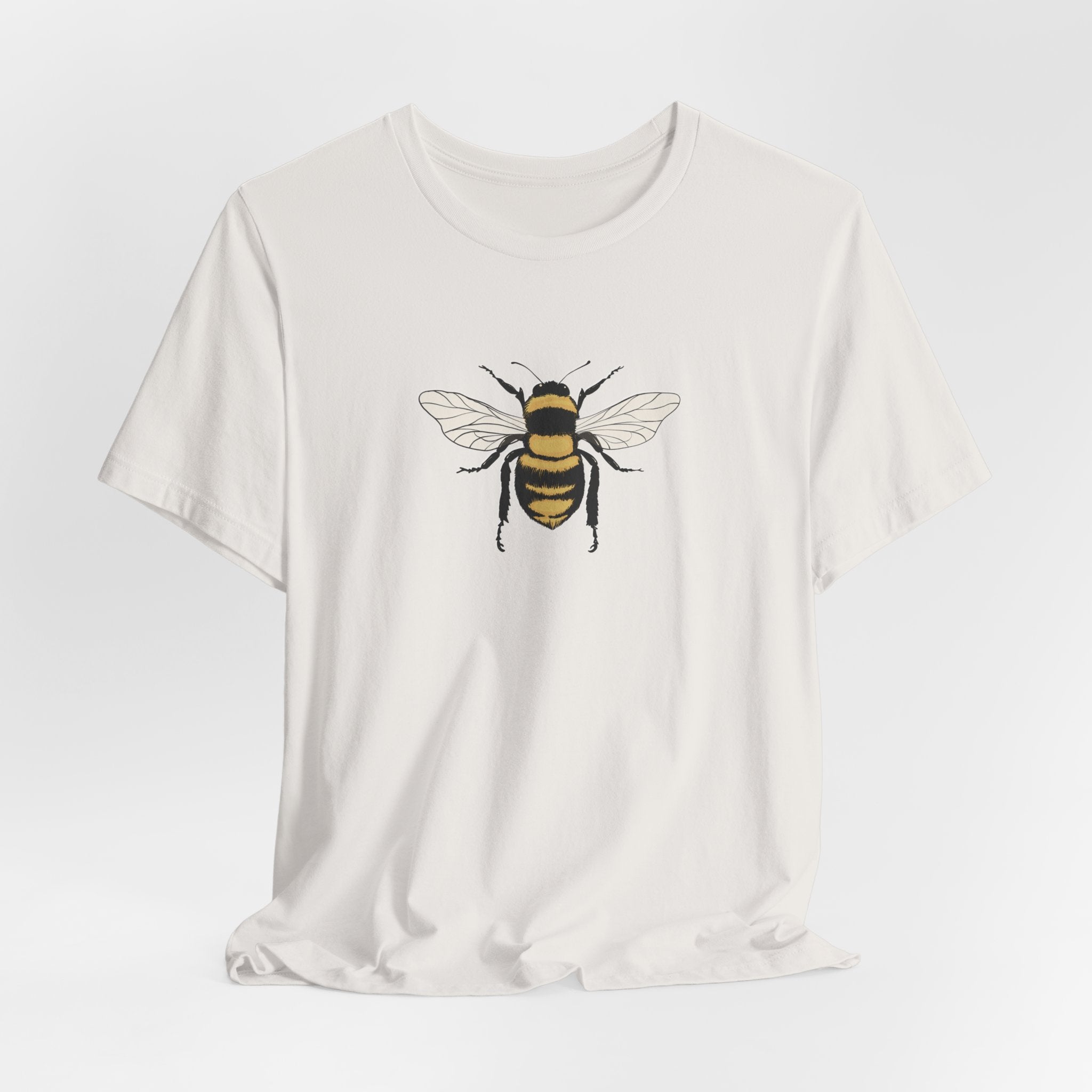 White t-shirt with a bee graphic on a light gray background