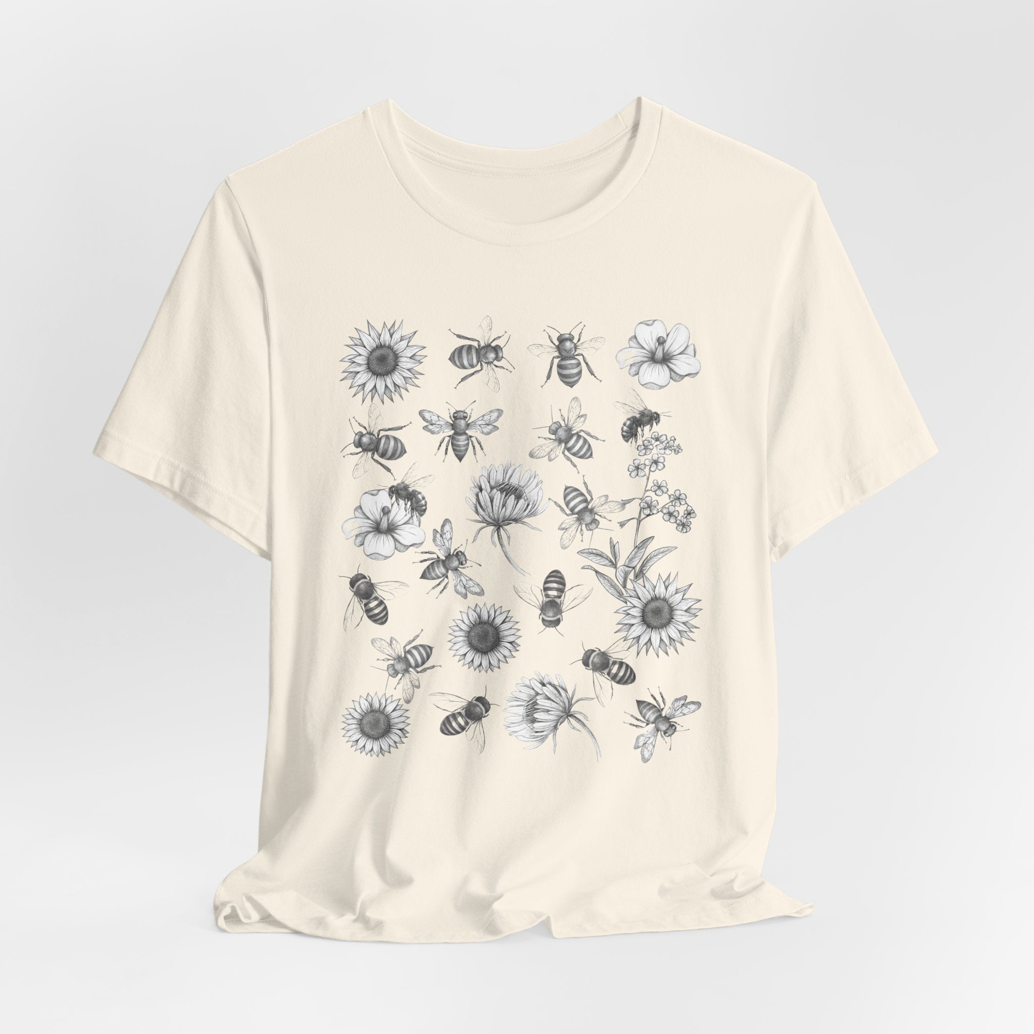 Beige t-shirt with black and white floral and bee design on a light gray background